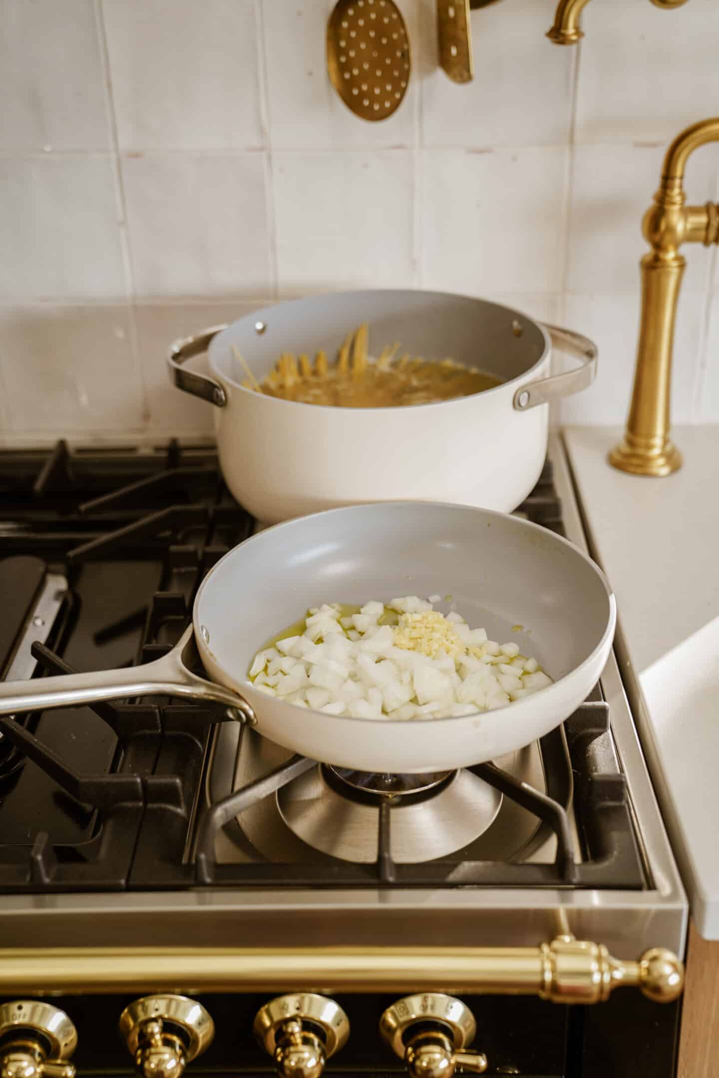 Cooking onions and pasta on stove