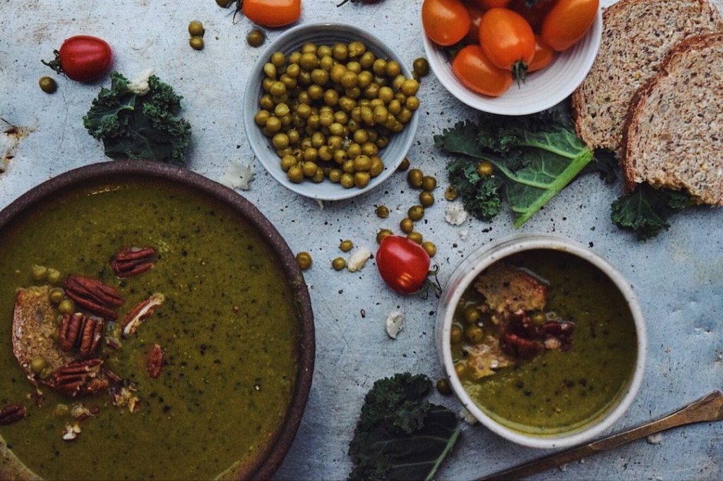 Cauliflower Kale Soup on a counter surrounded by ingredients