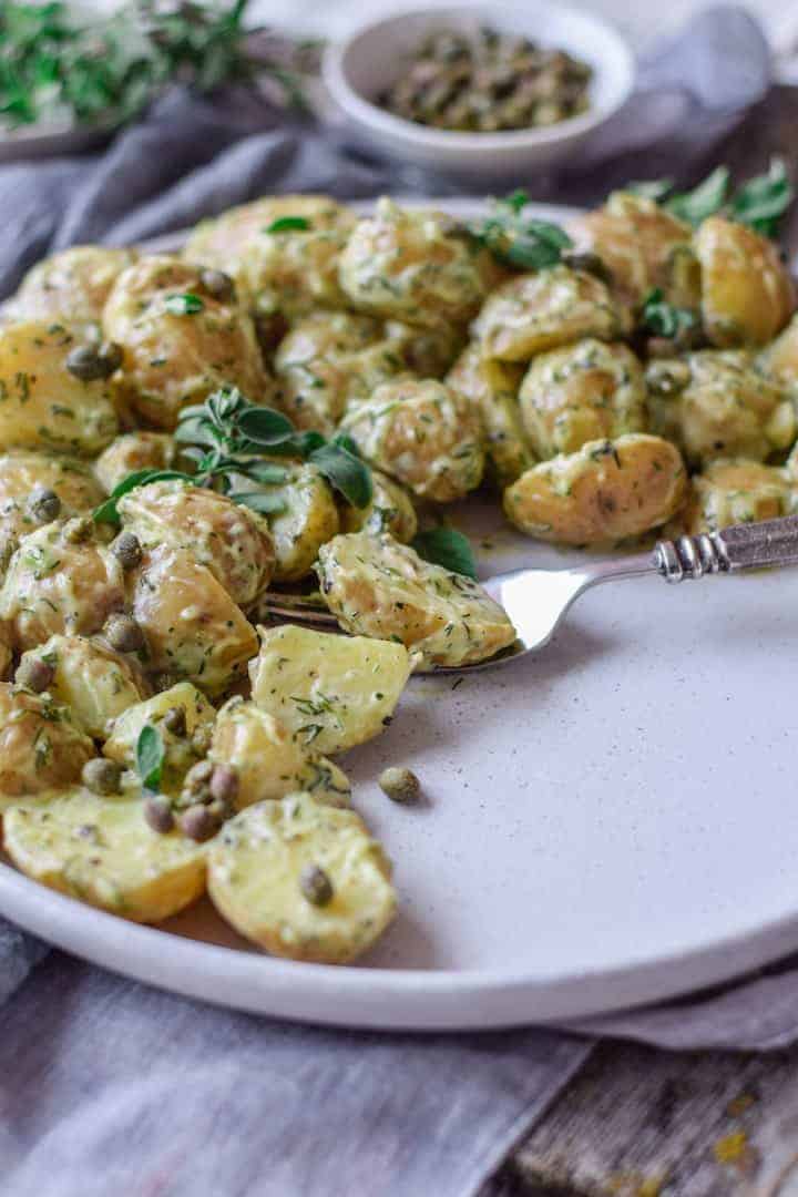 The best vegan potato salad sitting on a white plate.