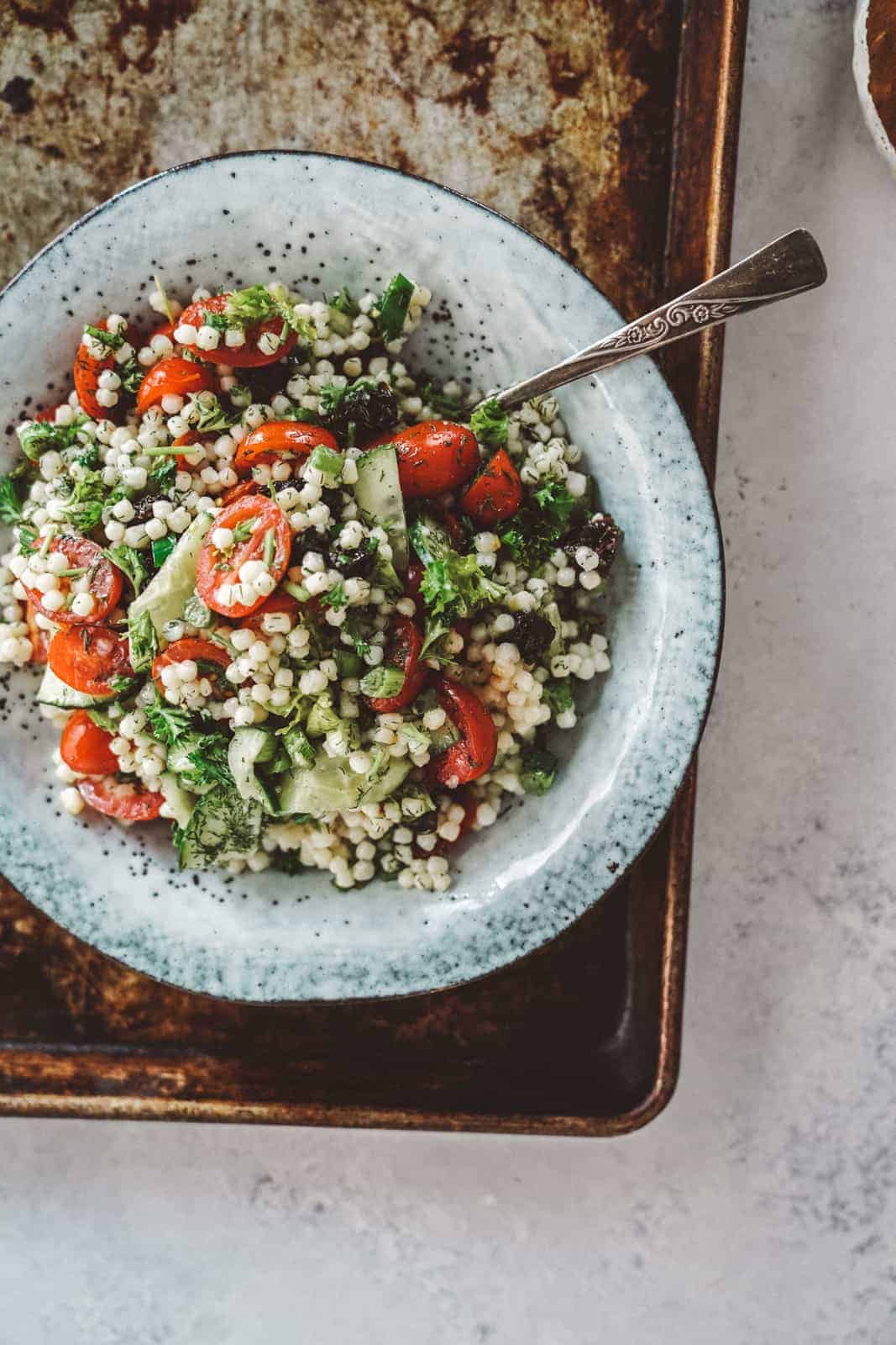 Tabbouleh and Couscous Salad in a bowl with a spoon