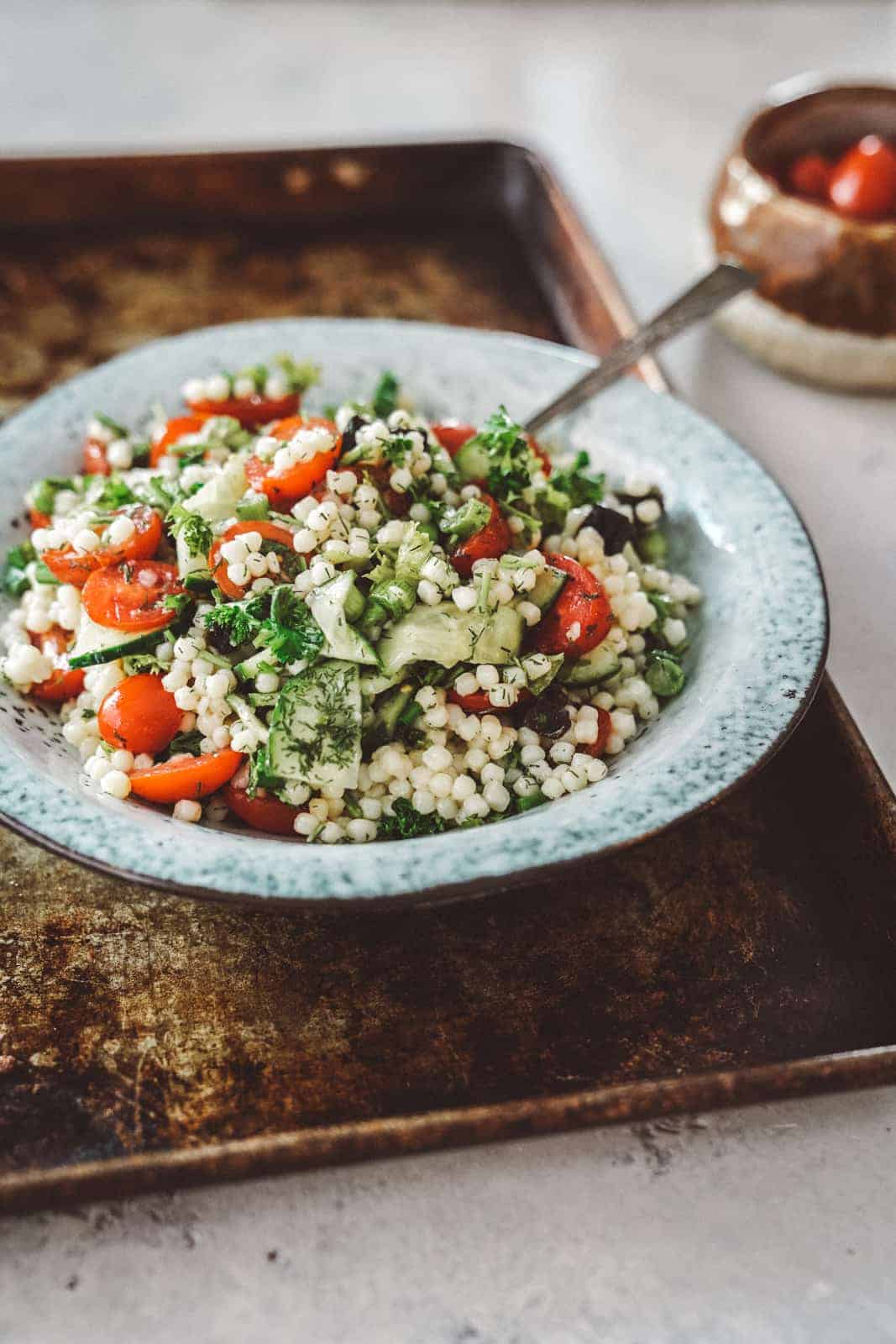 Bowl of Tabbouleh and Couscous Salad with a spoon in it