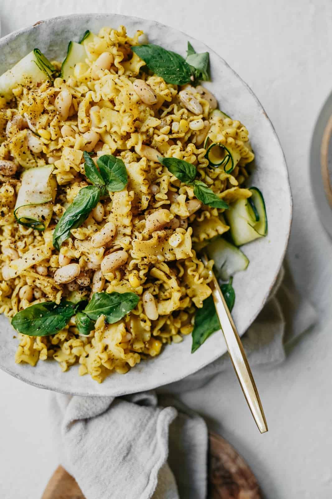 Close up of vegan pesto pasta on a plate with a fork