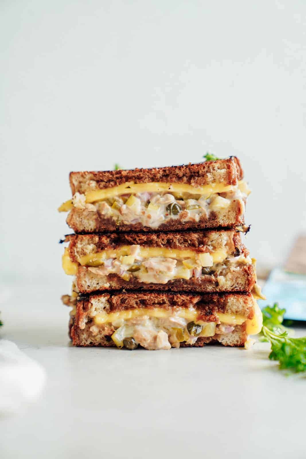 A stack of cheesy vegan tuna melts on countertop.