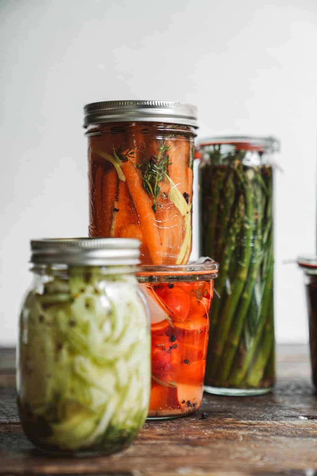 Several jars of pickled vegetables on a counter 