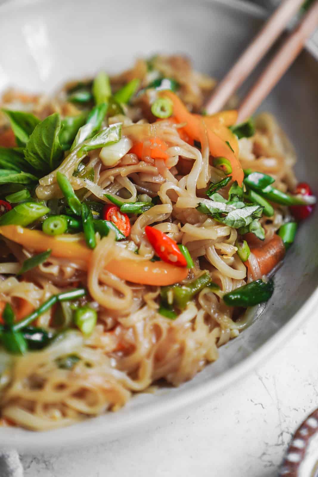 Extreme close-up of the beautiful, colourful drunken noodles recipe in a bowl.