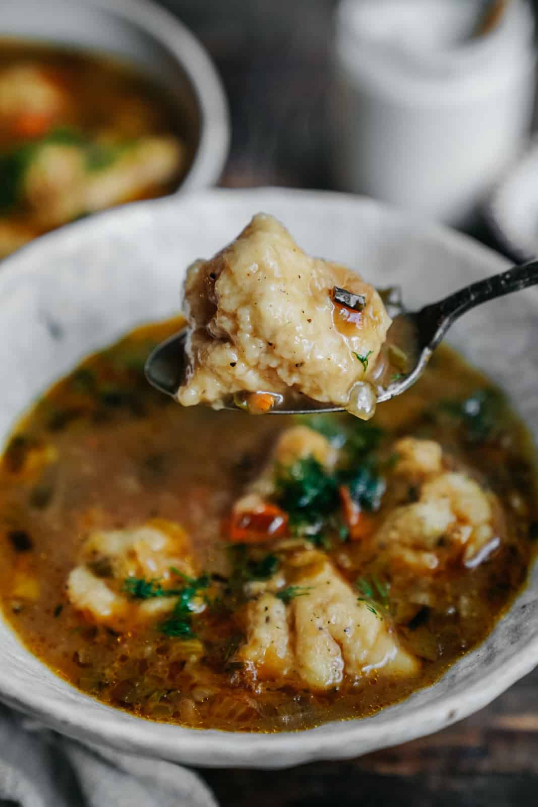 Vegan dumplings with soup and a spoon scooping out the dumplings