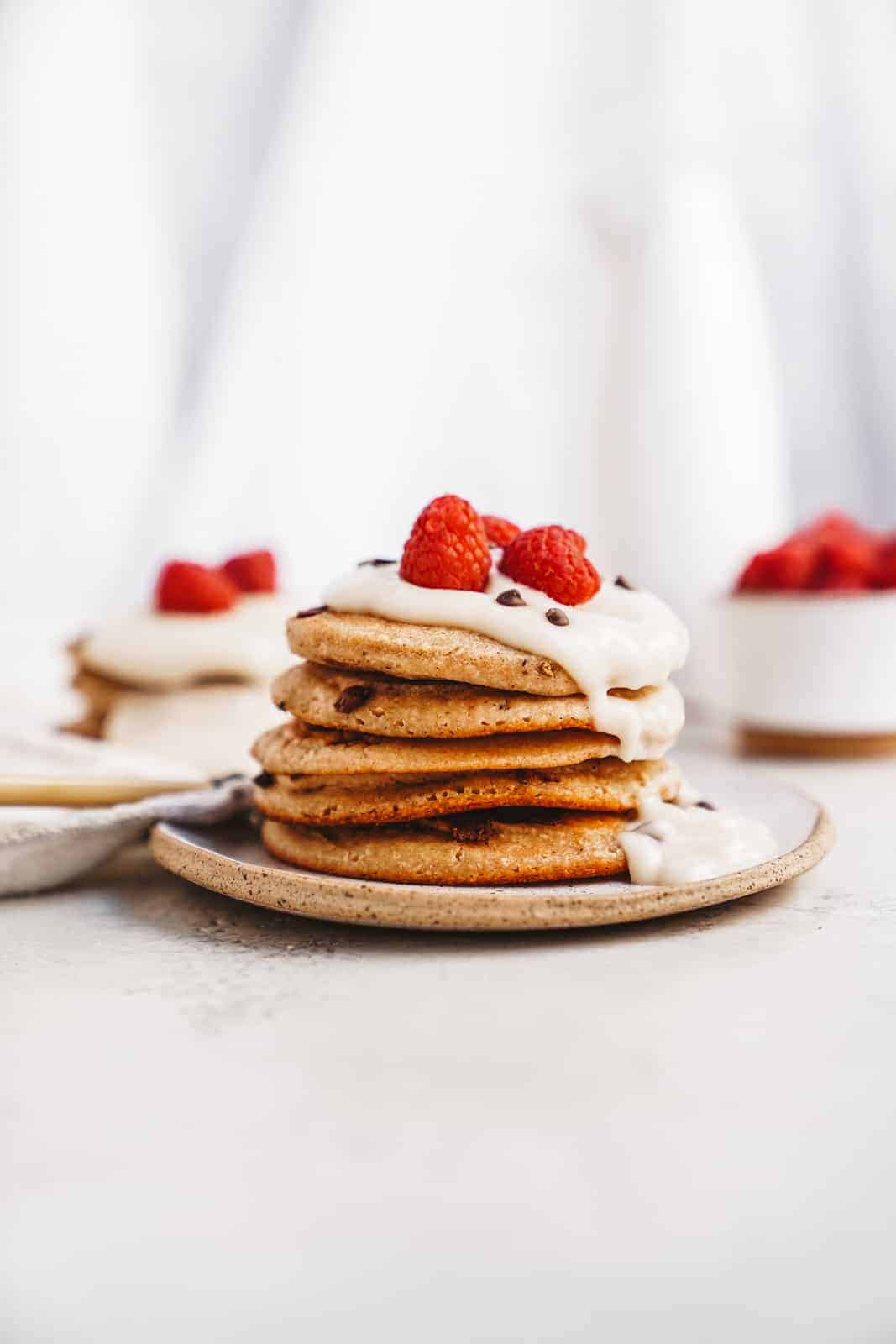 Vegan Protein Pancakes in a stack with raspberries on top 