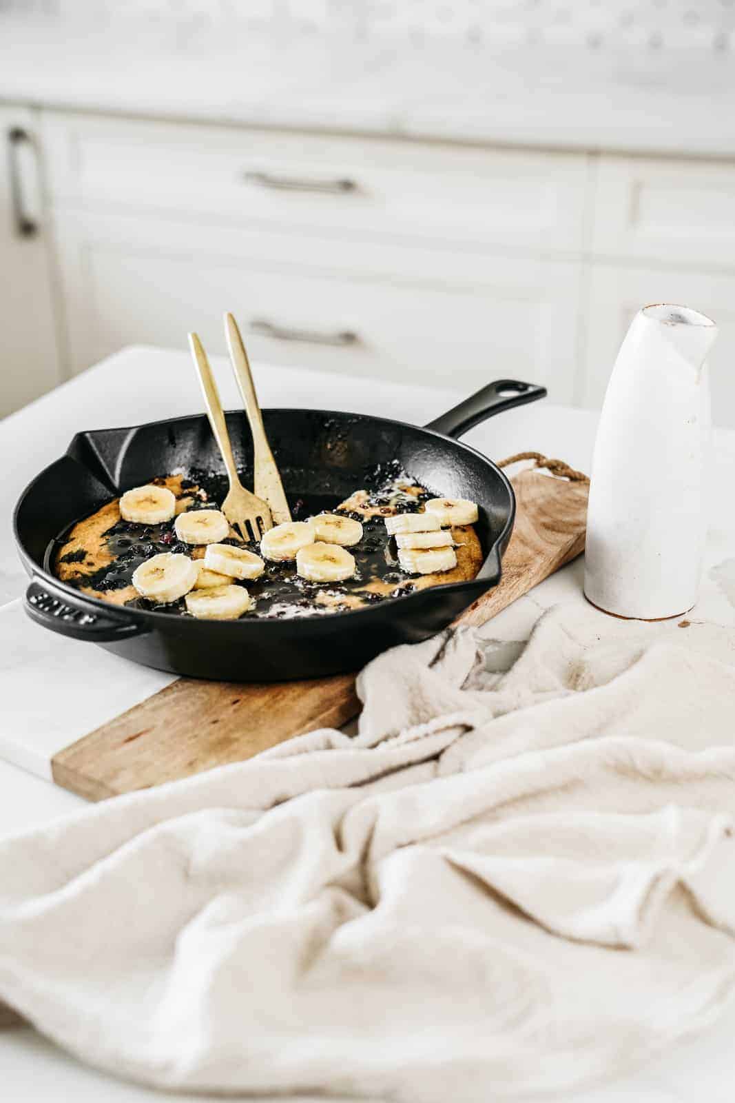 Skillet with vegan blueberry pancakes in it.