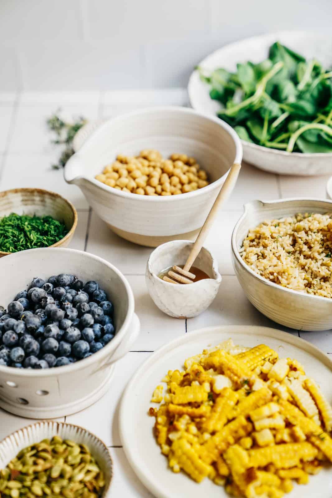 Ingredients for Vegetarian Picnic Salad scattered across countertop in bowls.