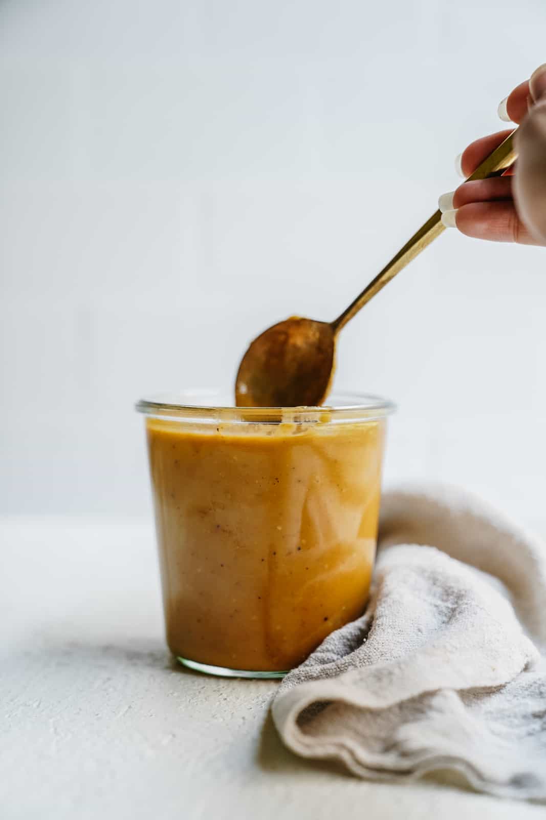 Vegan Tomatillo Dressing on countertop with spoon dipping into it.