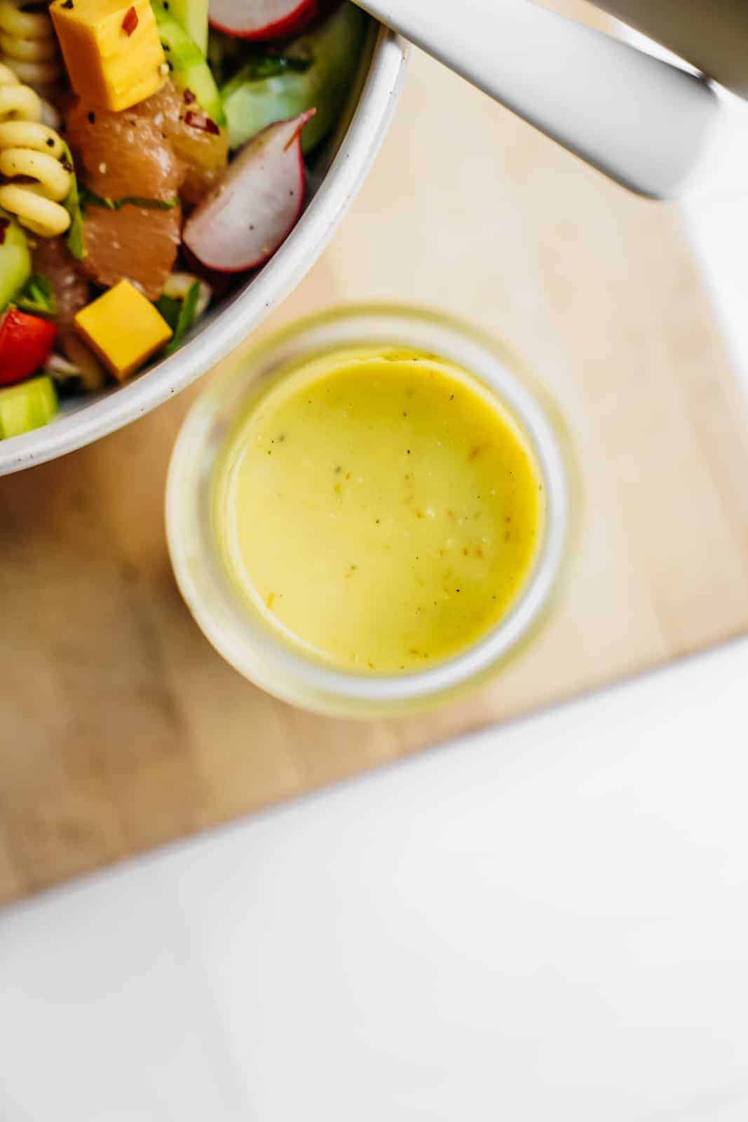 Glass container of Jalapeno Tomatillo Dressing for Vegan Pasta Salad