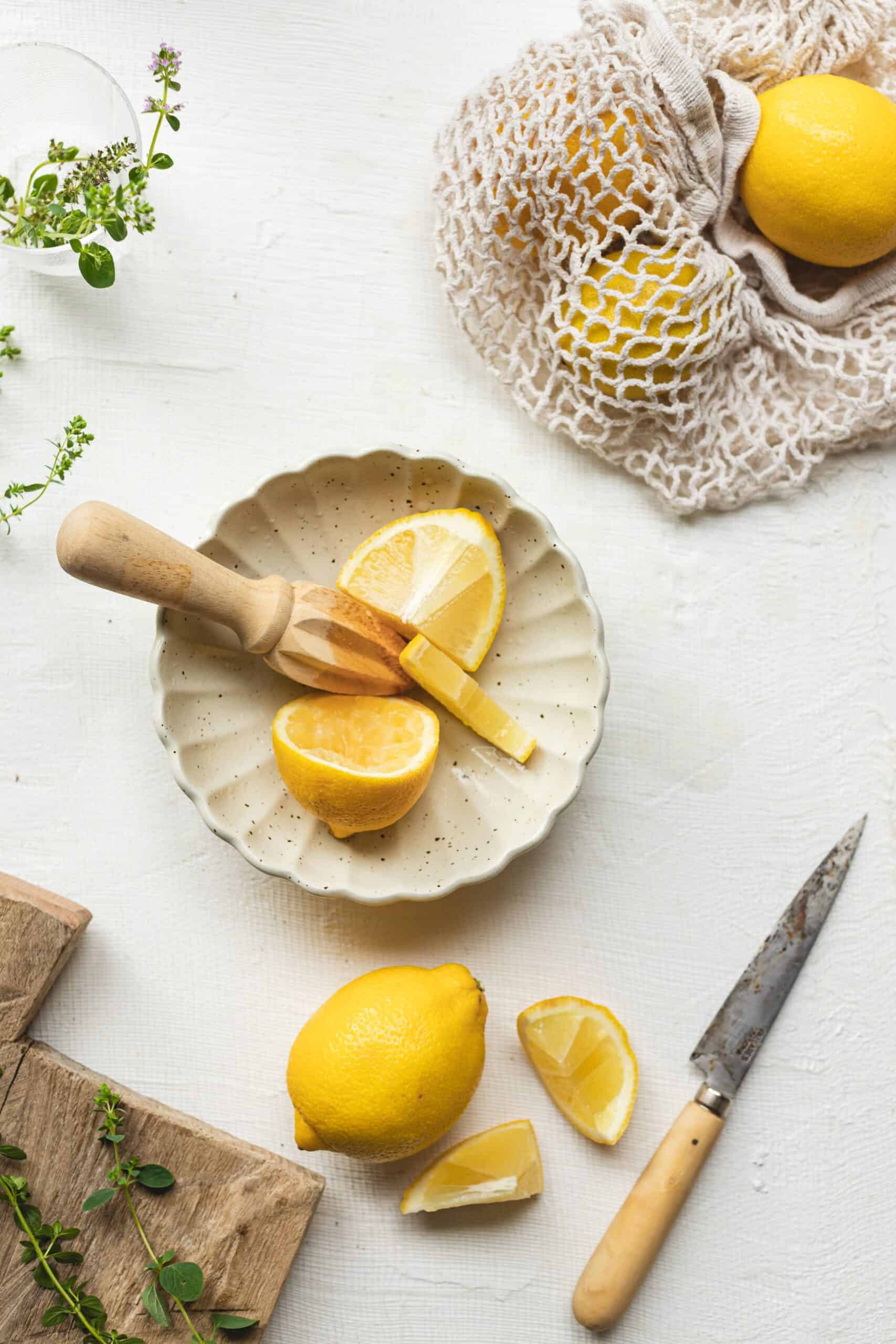 Lemon being muddled in bowl to add to Greek Salad Dressing.