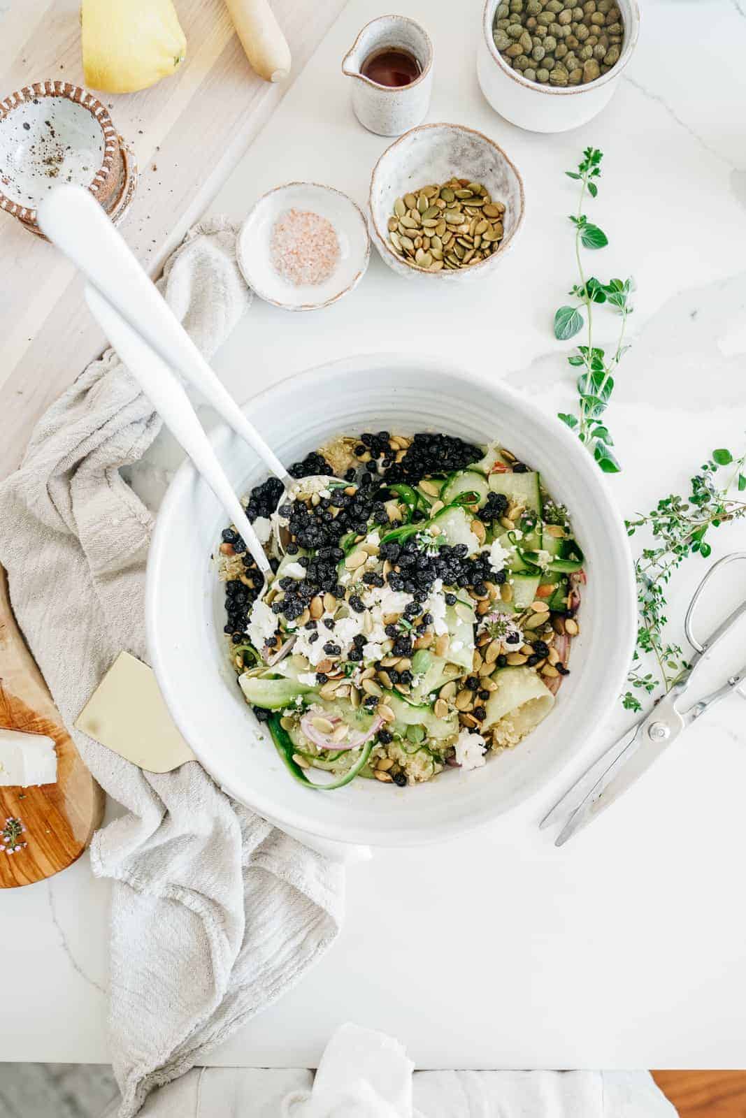 Big salad bowl of vegan shaved cucumber salad with dried blueberries. 