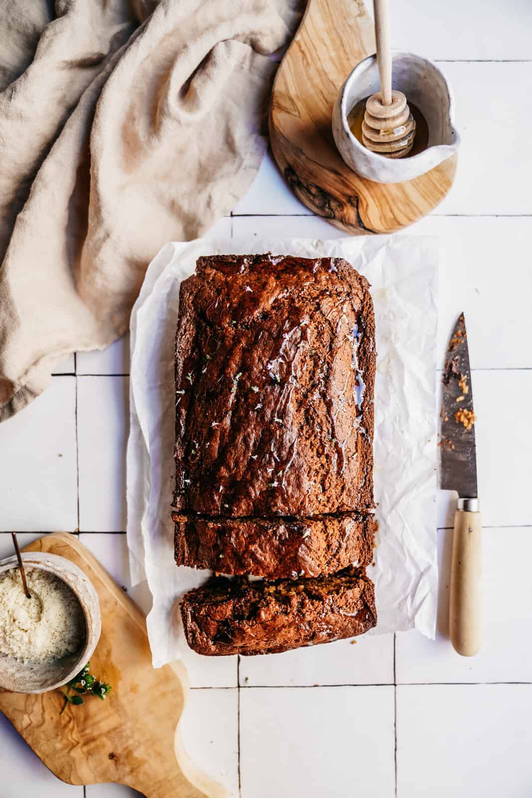 Zucchini Banana Bread on counter with knife, with a few slices cut out of it.