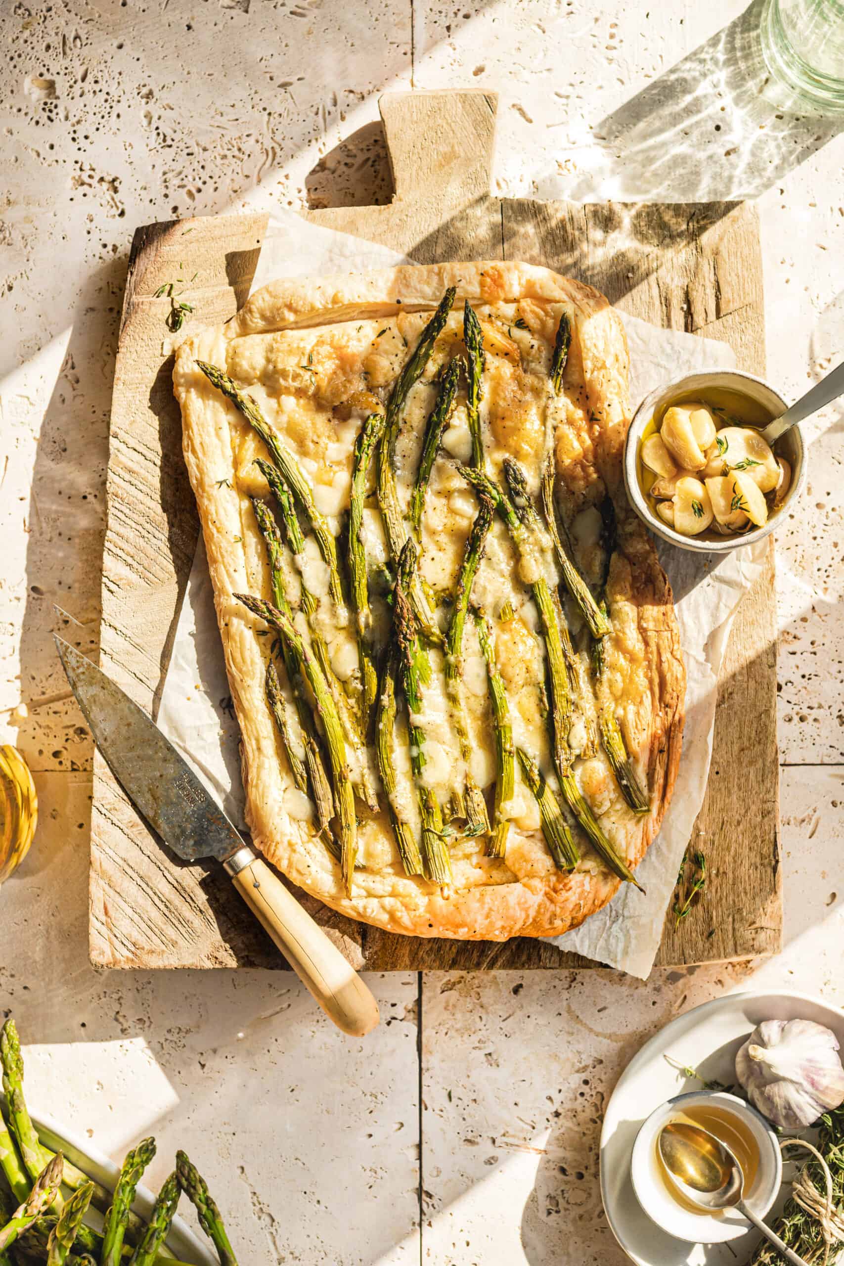 Asparagus and Cheese Tart on cutting board with sun shining through window.