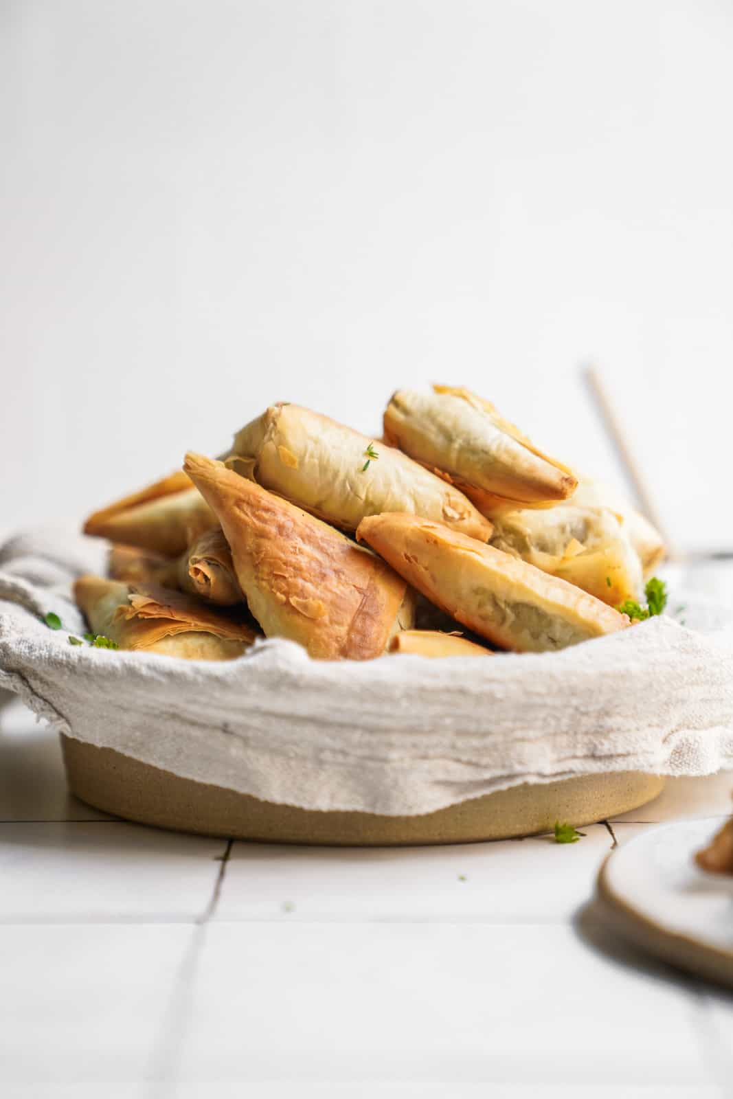 Side angle of Mushroom Pastry Bites in a bowl on counter.