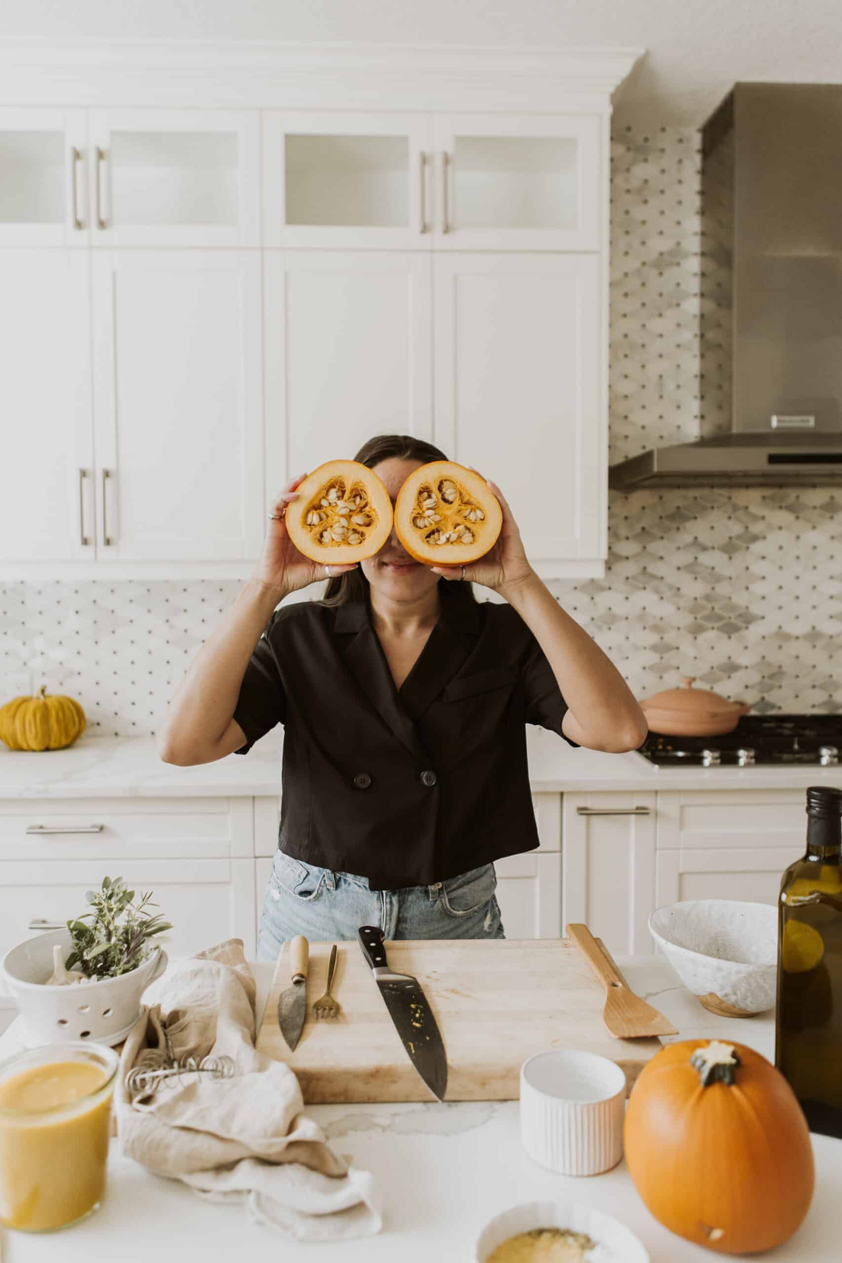 Maria holding up the sliced pumpkin to her eyes for the Vegan Pumpkin Mac and Cheese