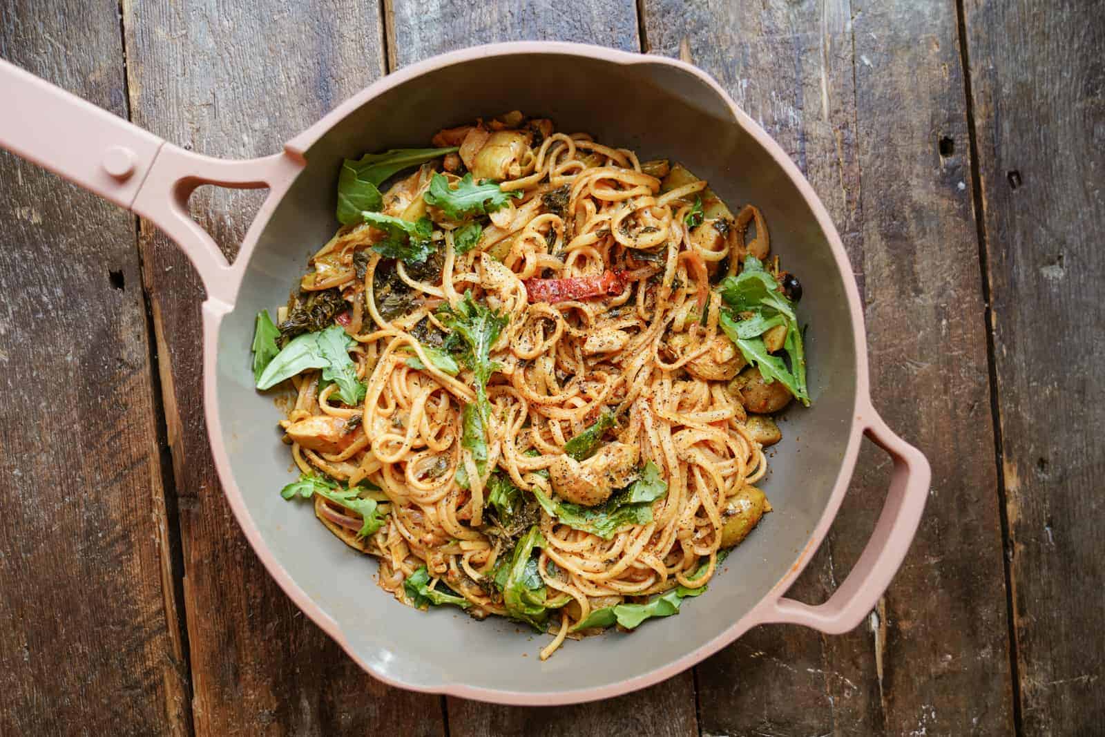 pot of one-pot vegetarian pasta on wood tabletop.