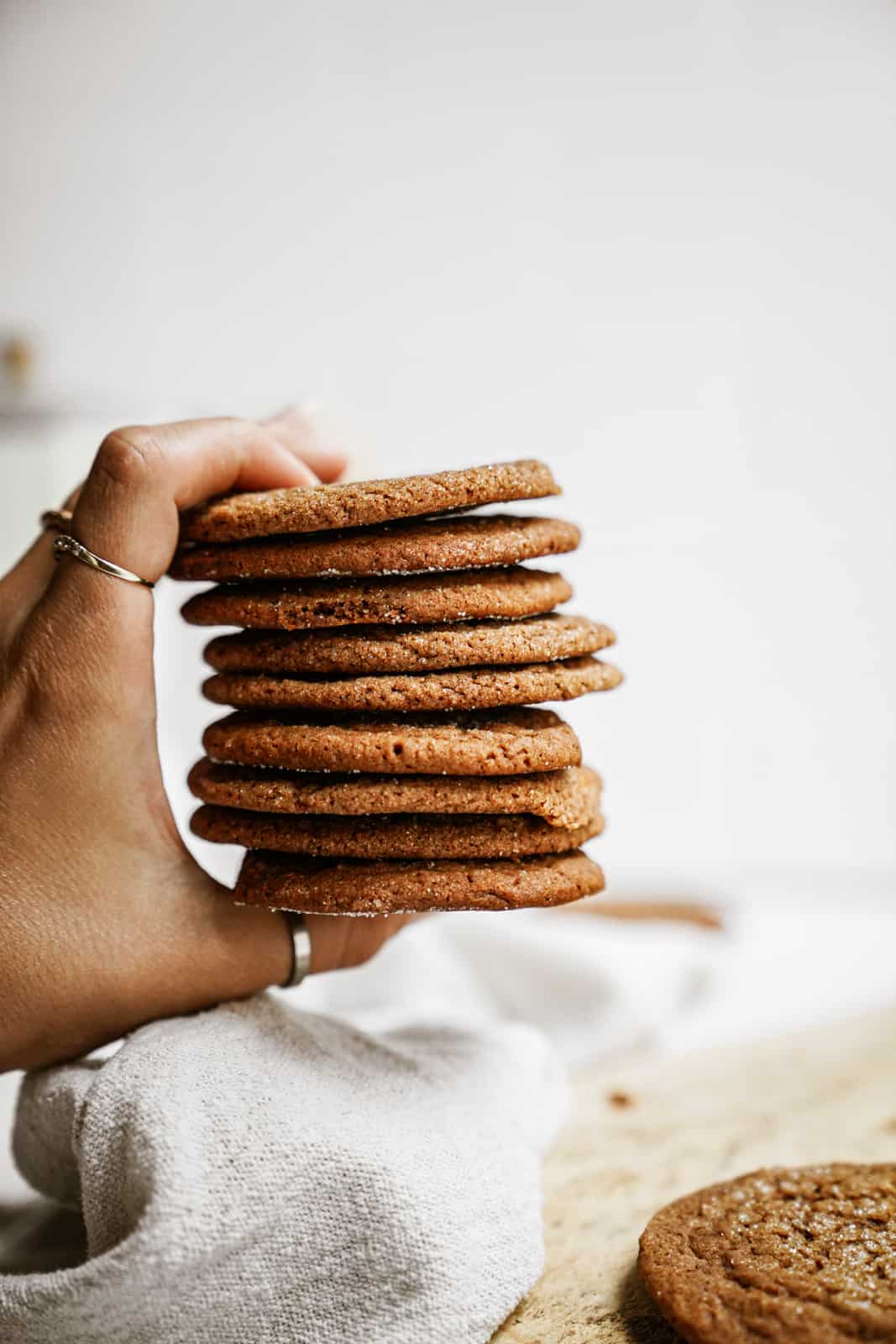 Hand holding a stack of Vegan Ginger Snap Cookies