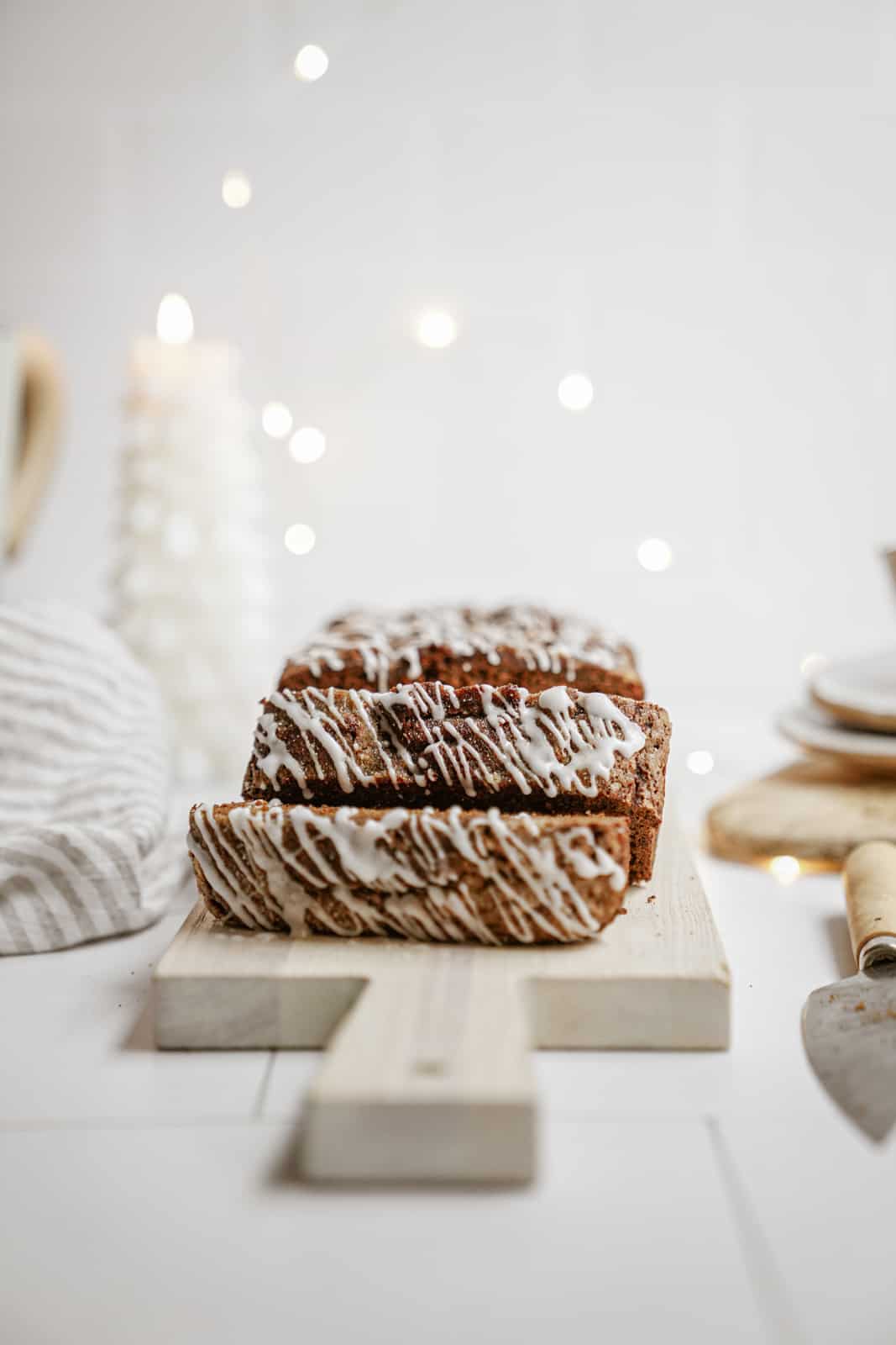 Vegan gingerbread loaf sliced on cutting board.