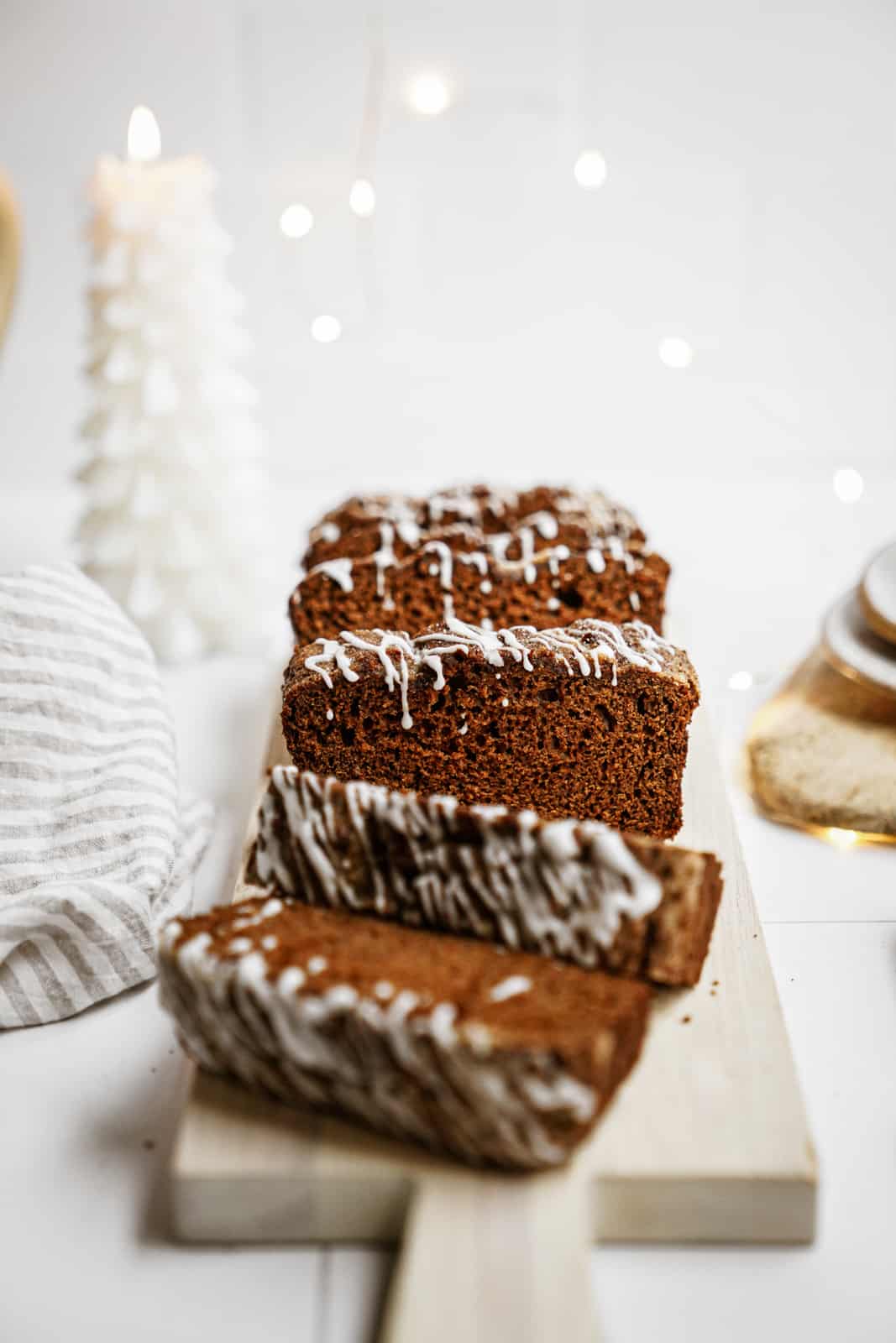 Vegan gingerbread loaf sliced on cutting board.