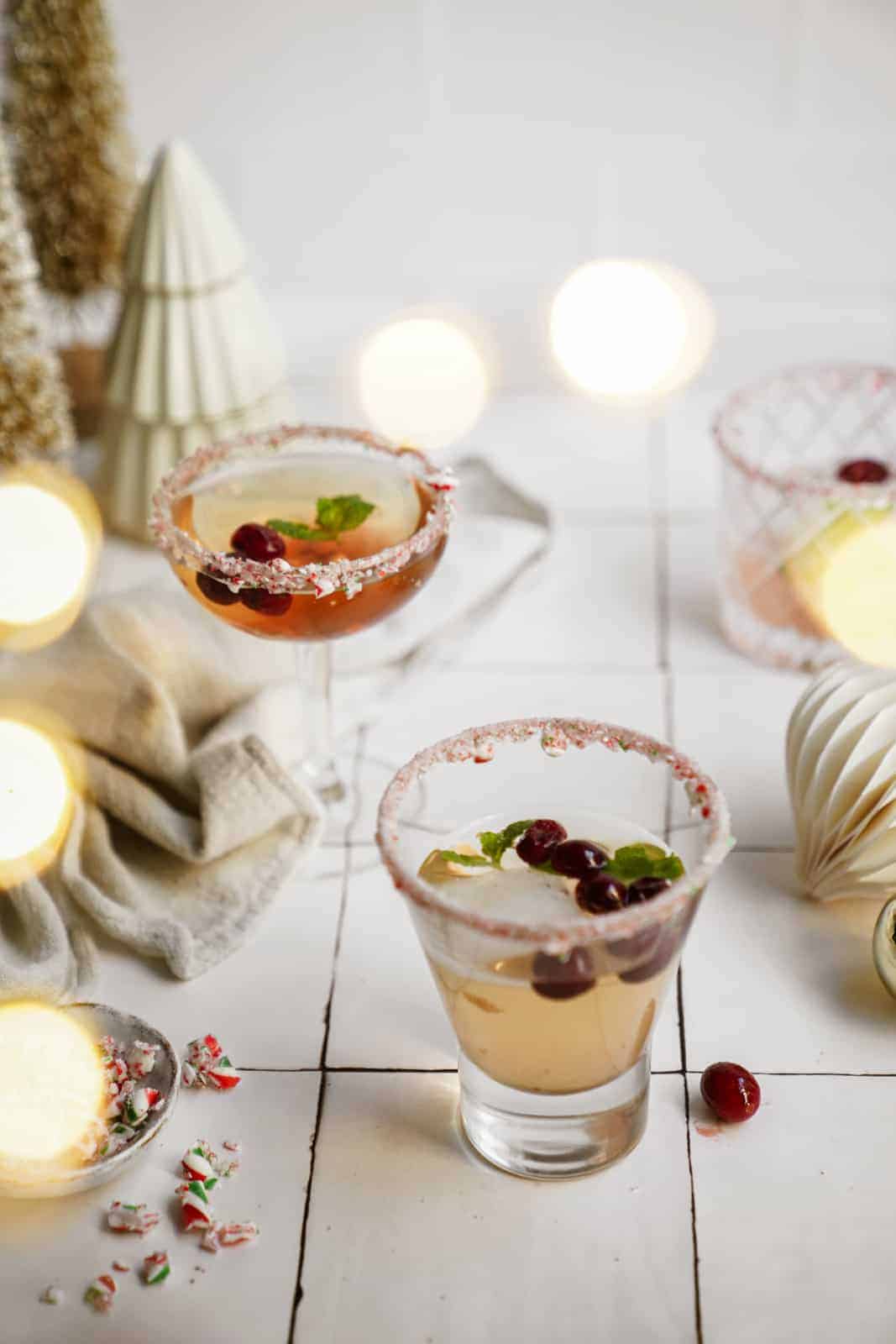 Candy cane martini in glasses on counter with a winter setting.