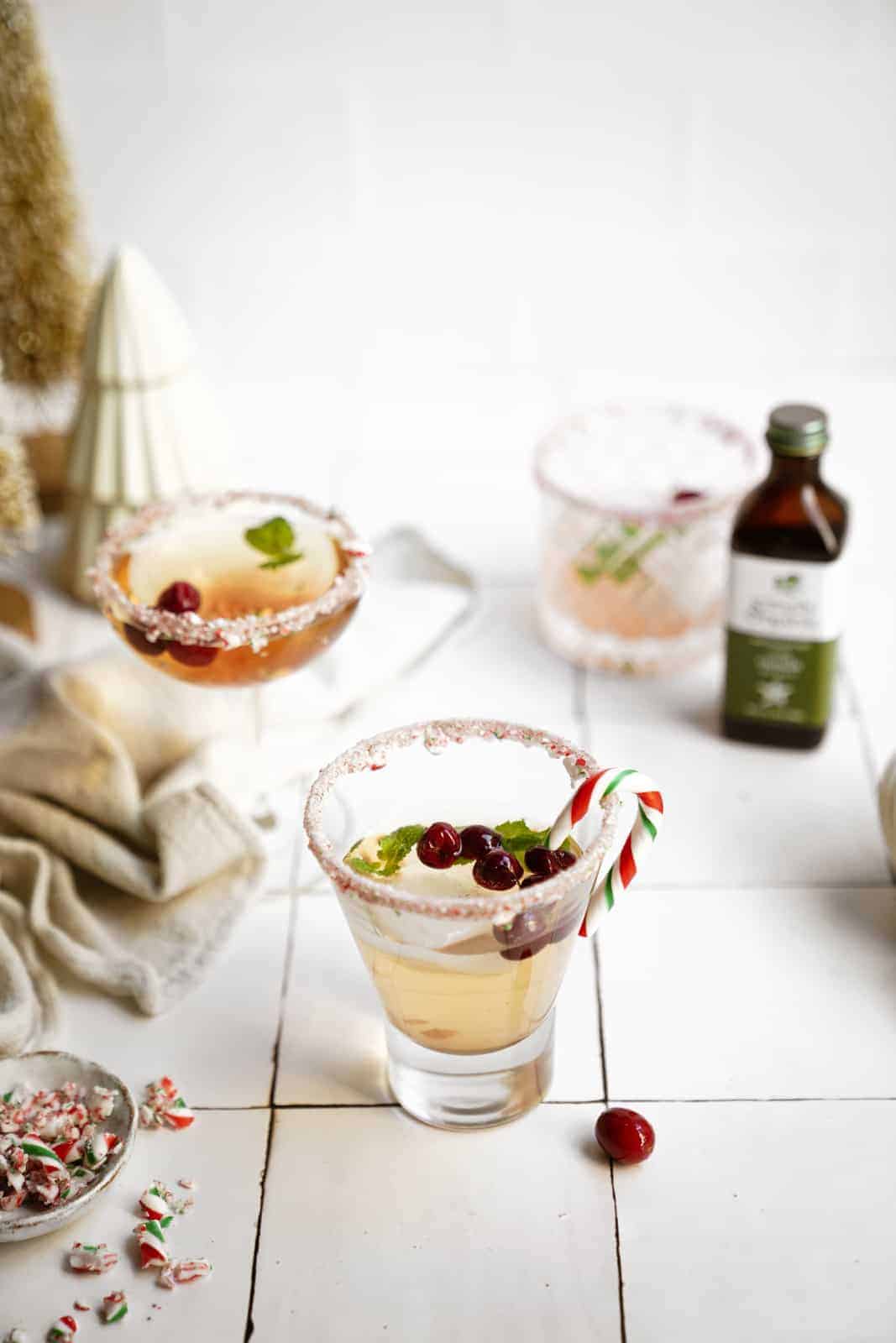 Candy cane martini in glasses on counter with a winter setting