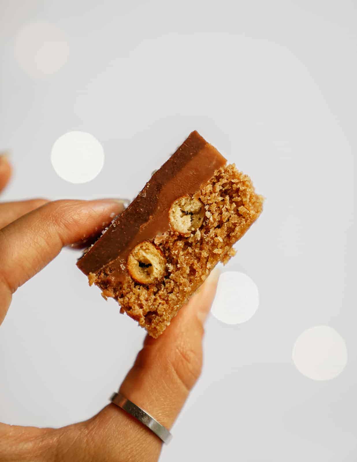 Hand holding a caramel pretzel bar.