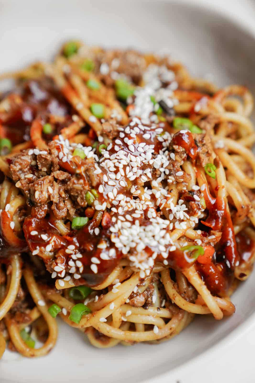 Closeup of vegan dan dan noodles in a white bowl