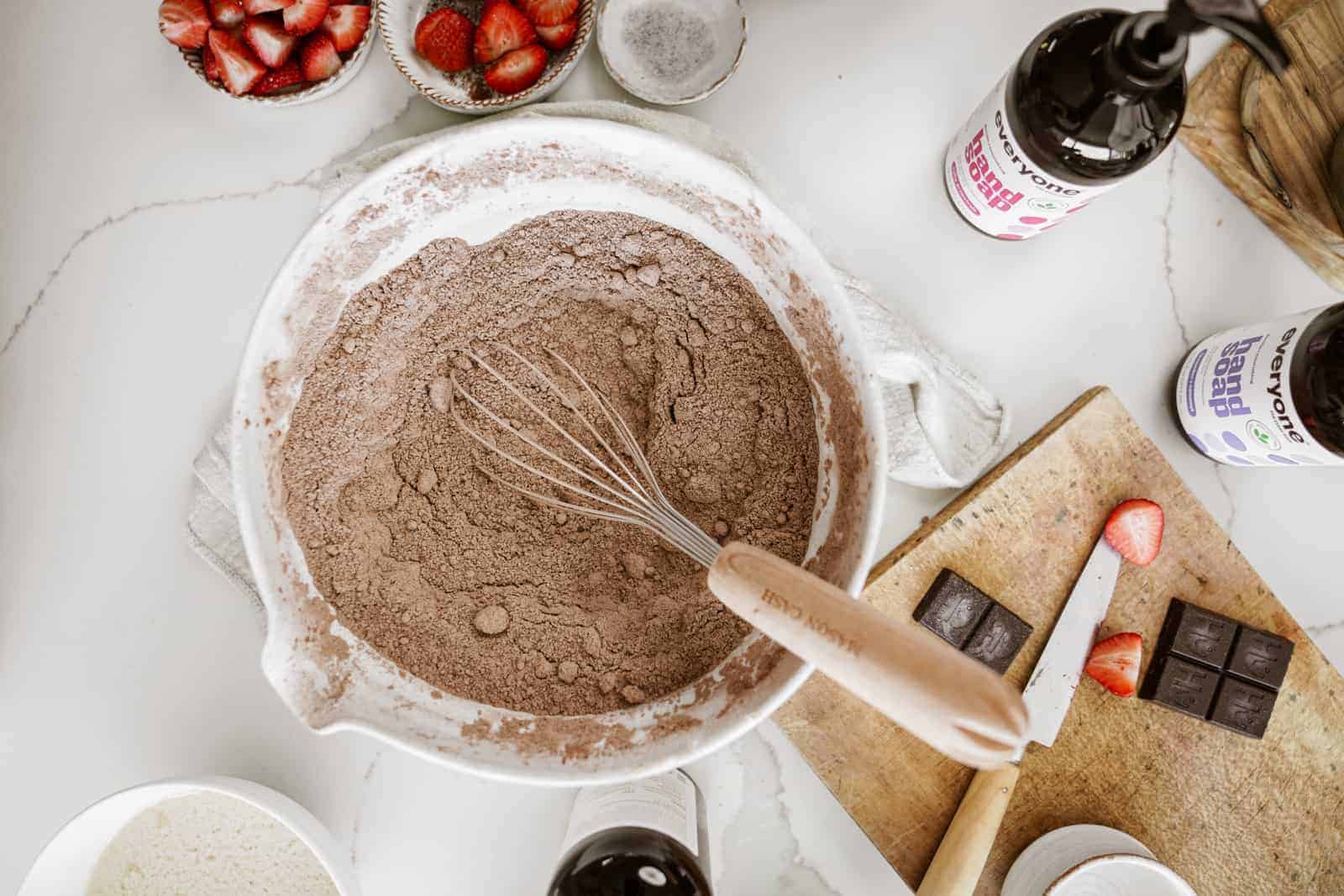 Bowl of cake mix with whisk on countertop ready to be made into vegan sheet pan cake