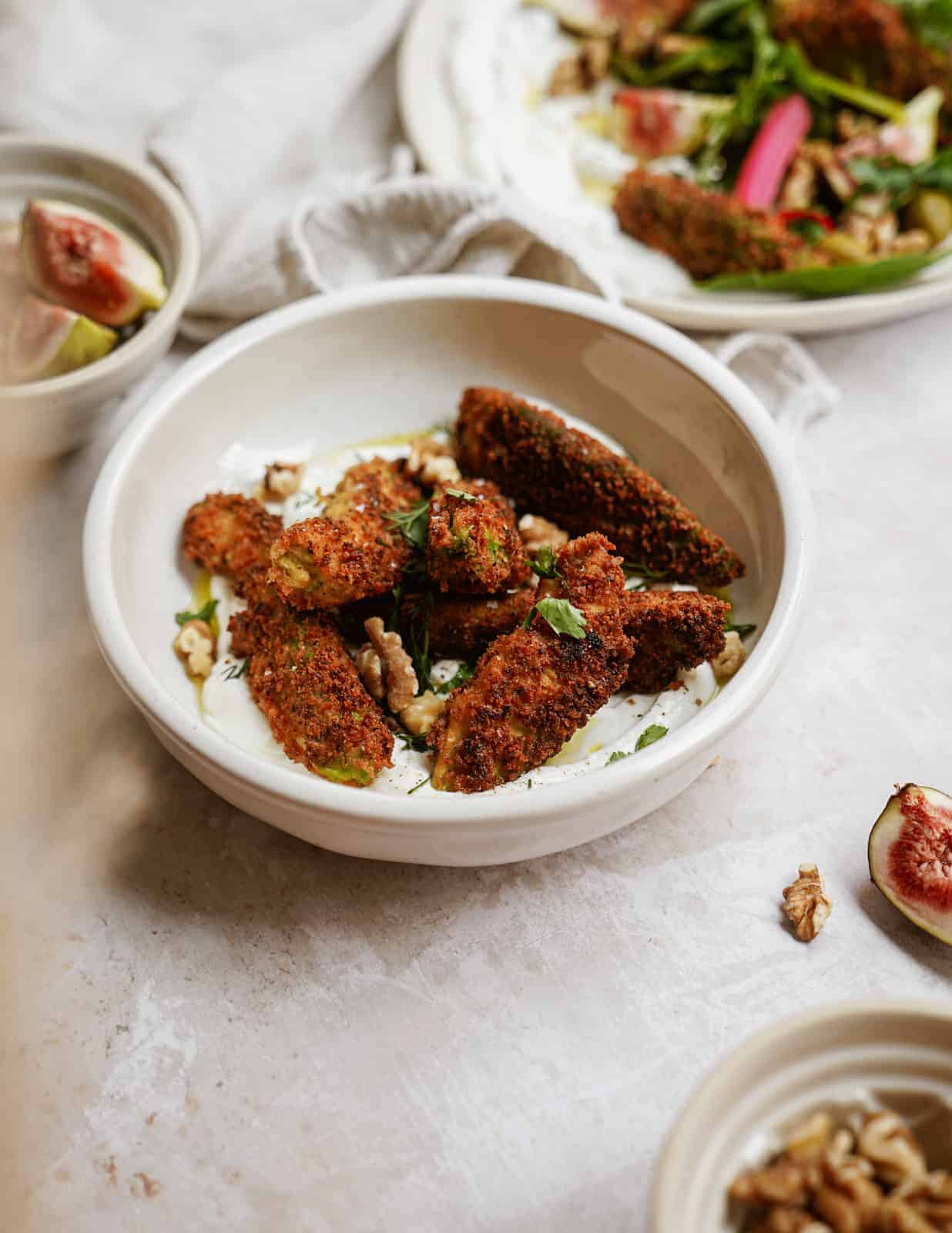 Fried Avocado in a bowl on a counter surrounded by other ingredients.