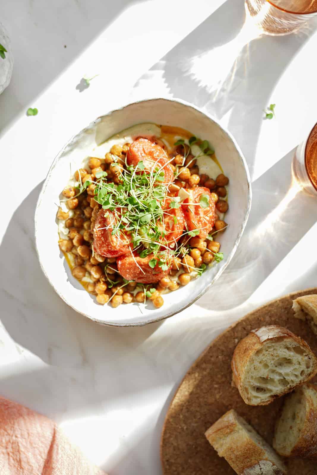 oven-roasted chickpeas in a white bowl with slices of bread next to it