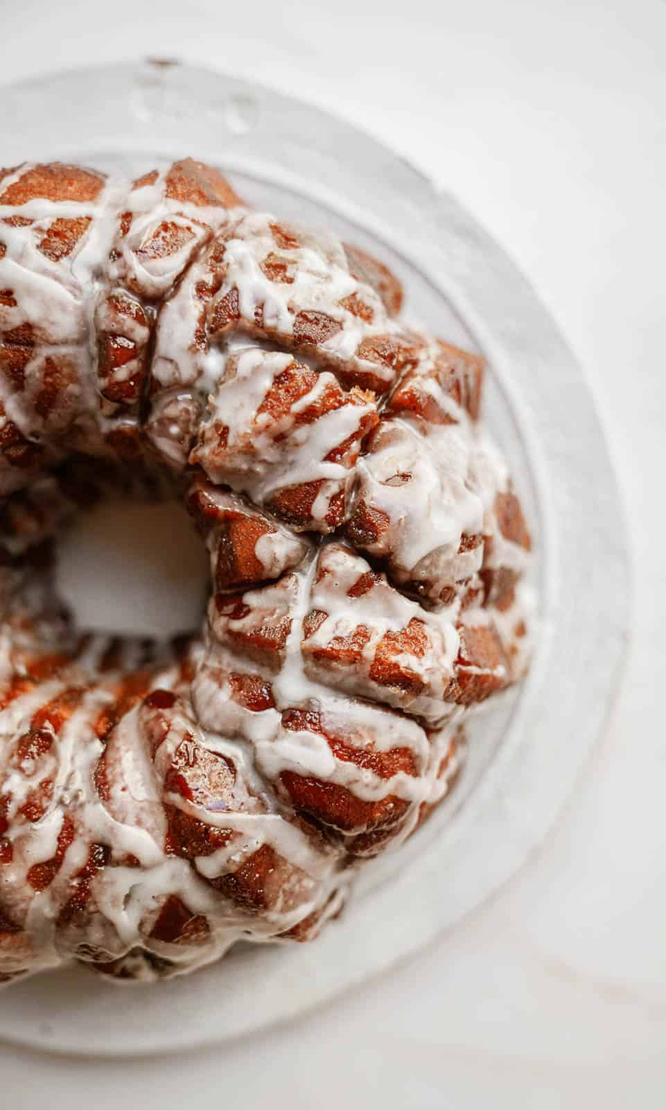 Vegan monkey bread on plate drizzled with icing