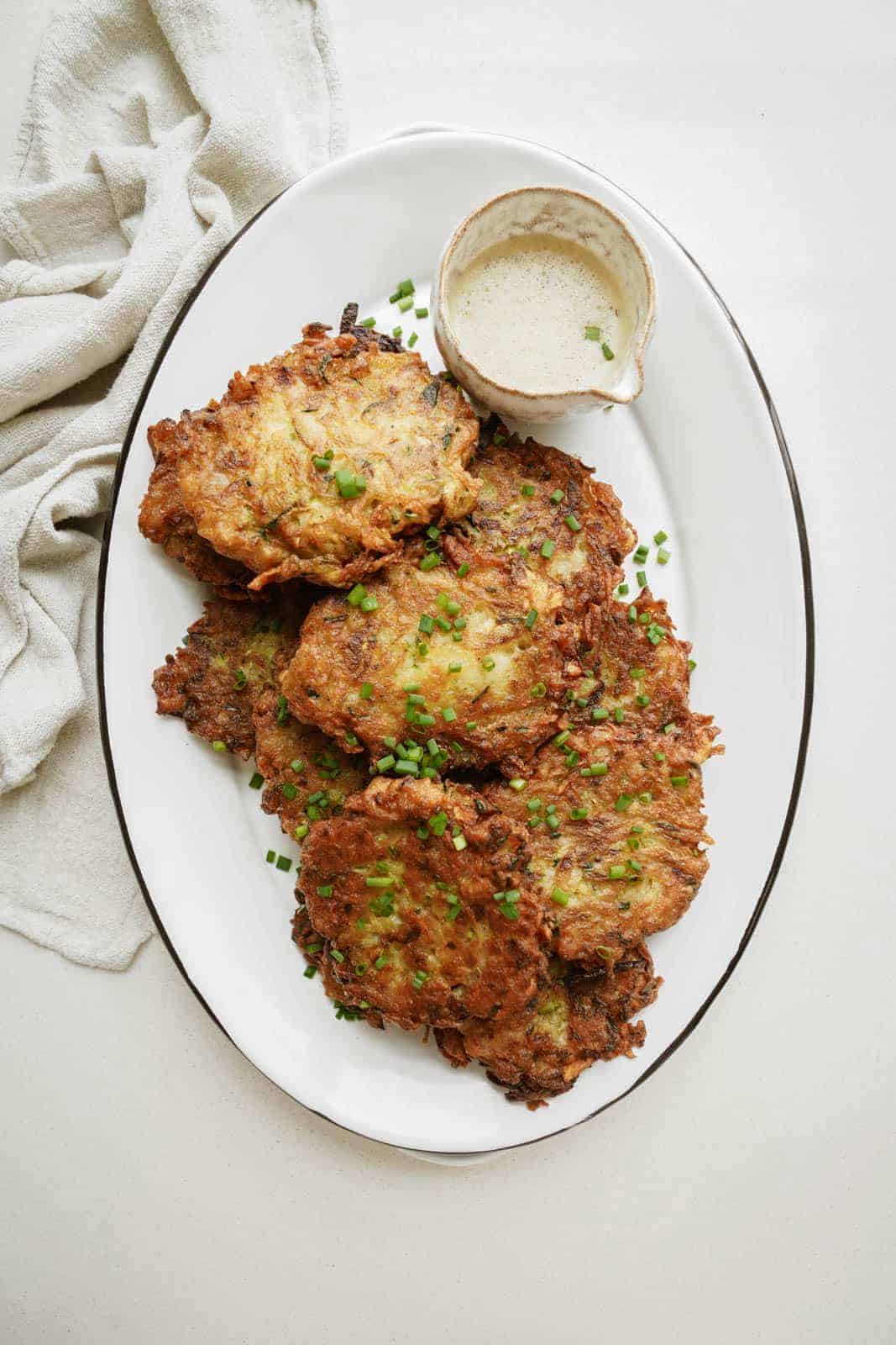 Zucchini Potato Pancakes on serving plate with dipping sauce