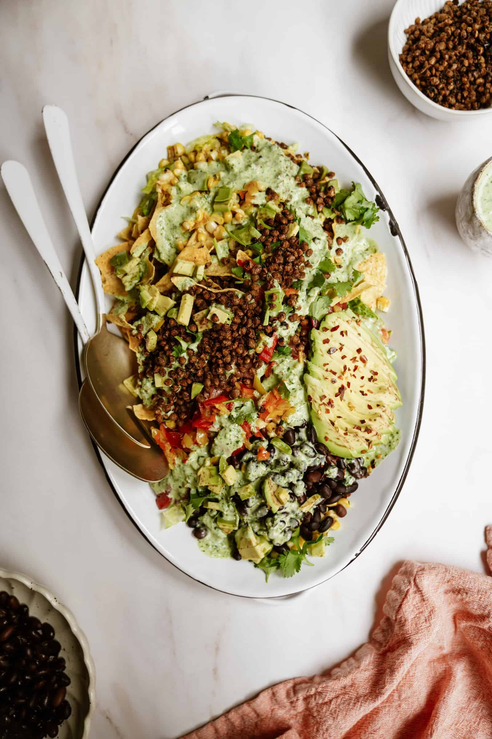 Vegan taco salad in a serving bowl with serving spoons