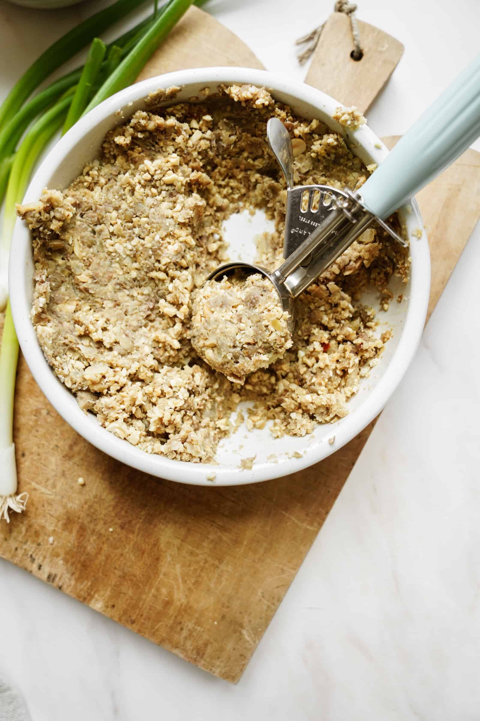 Lentil meatball ingredients being scooped out of a bowl