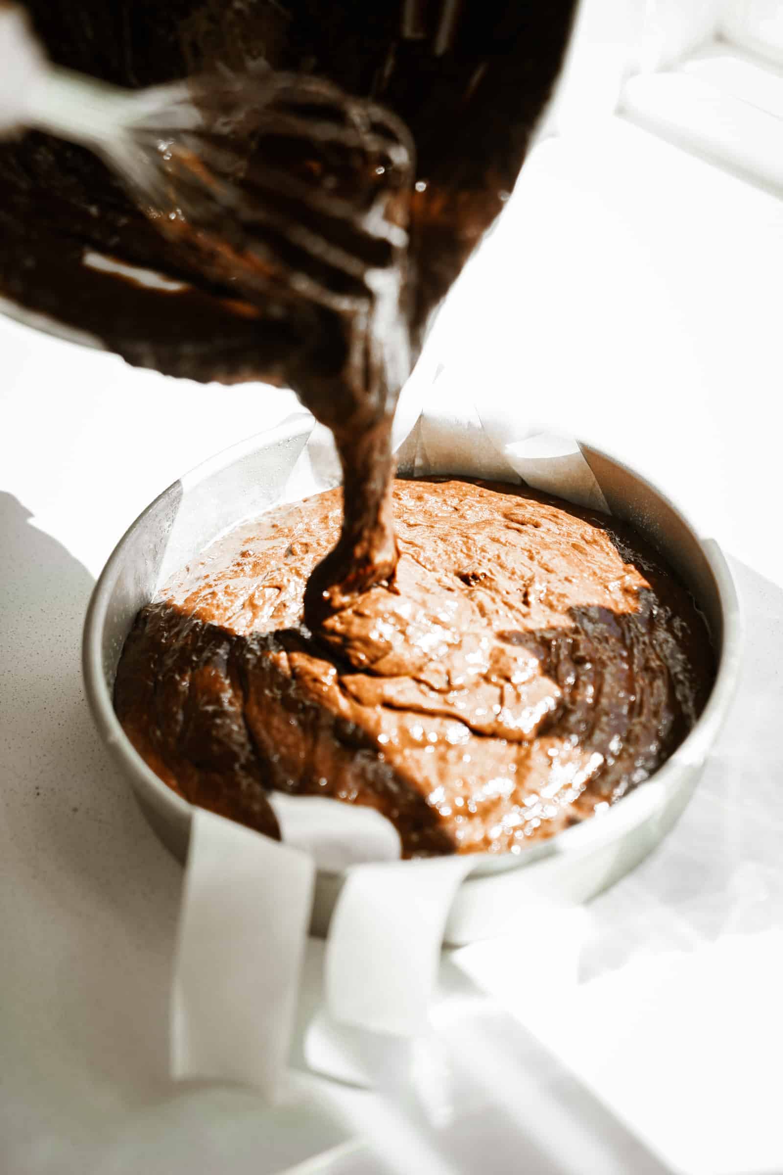 Cake batter being added to a baking pan