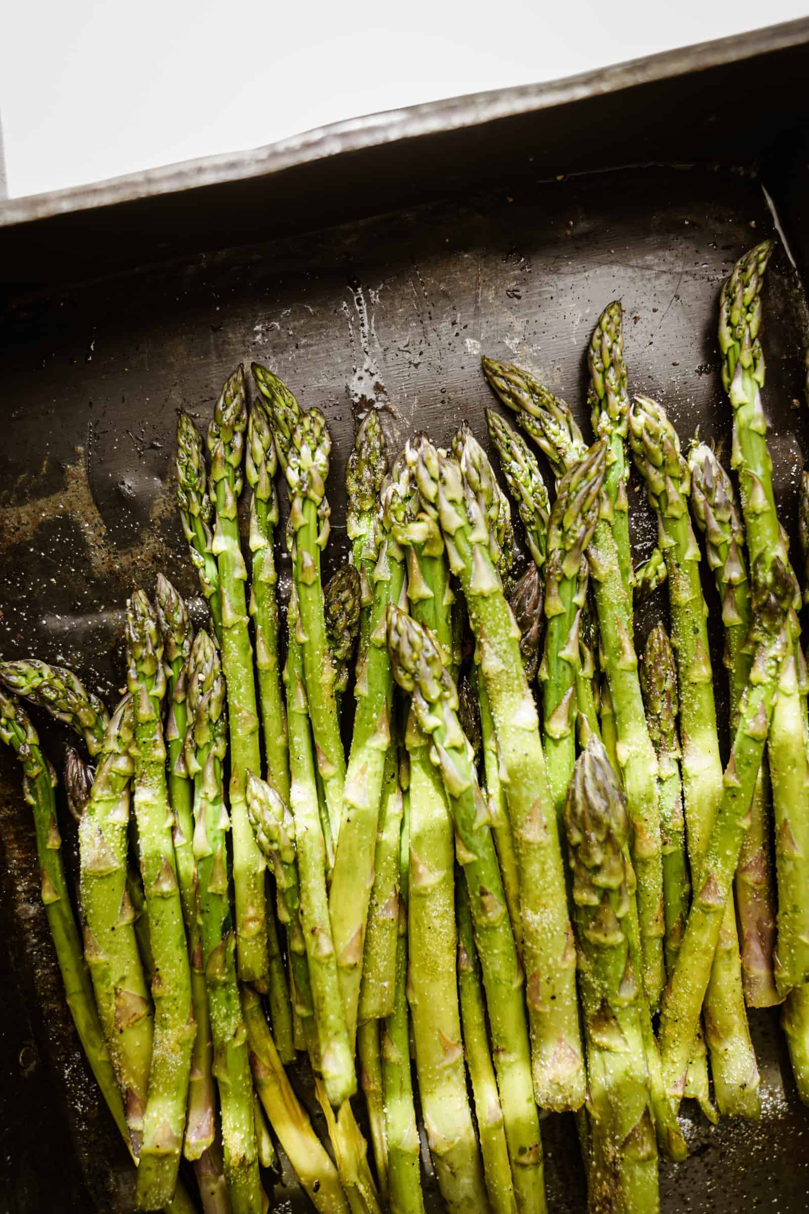 Raw asparagus on a baking tray