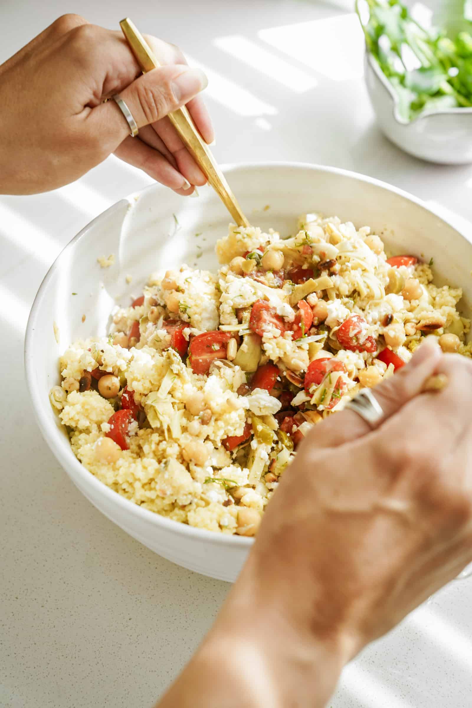 All ingredients being added to the Mediterranean Salad Recipe in a large serving bowl