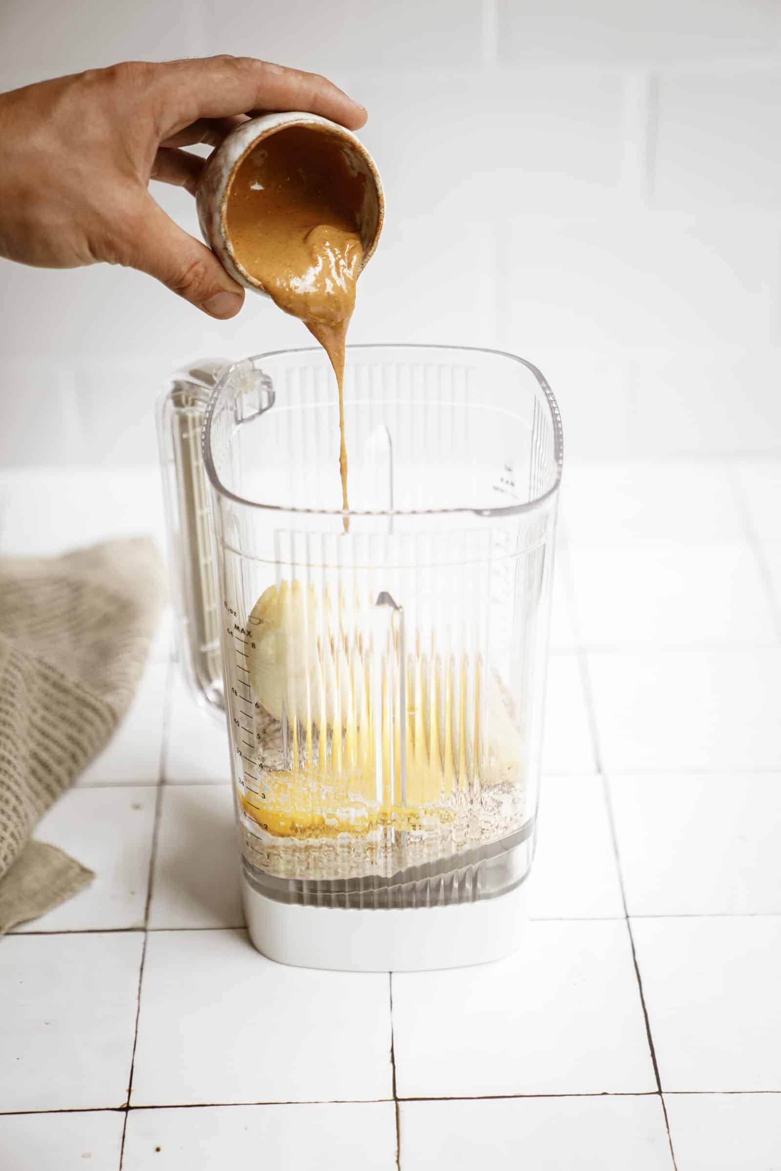 peanut butter being added into a blender for peanut butter banana pancakes