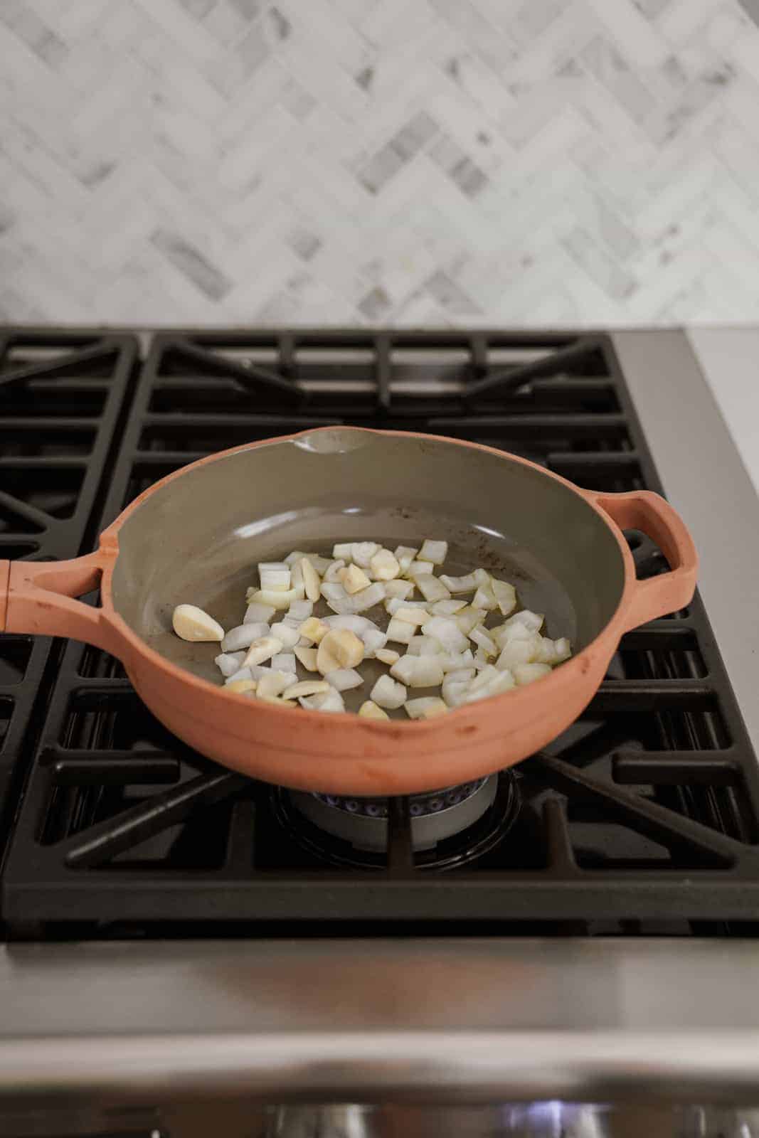 Onion and oil in a pan on a stove 