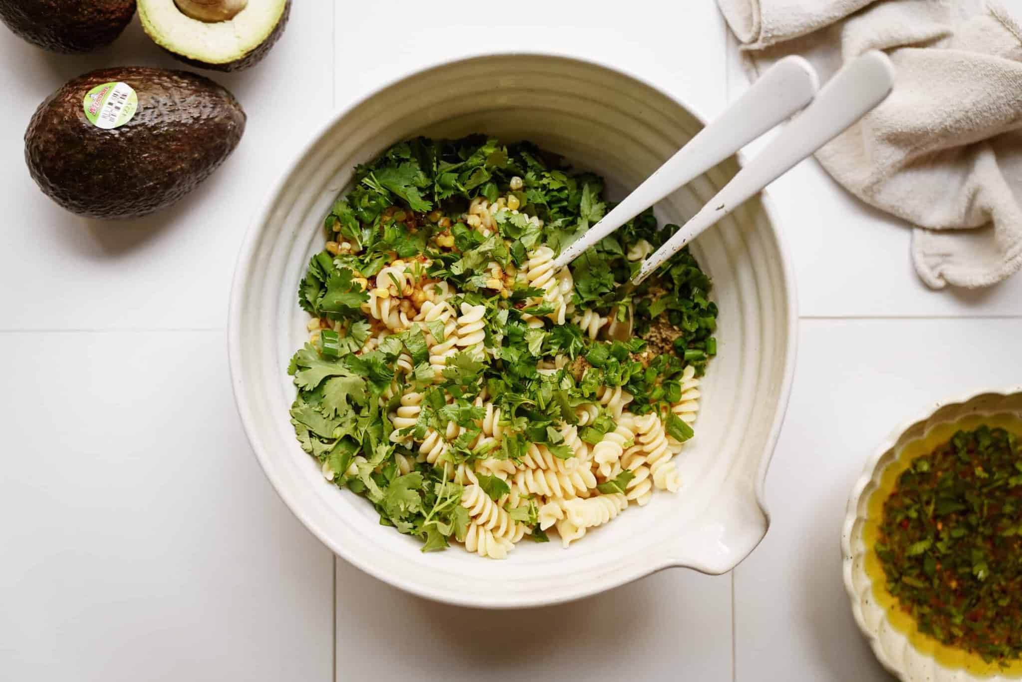 Pasta with herbs in bowl for avocado pasta salad