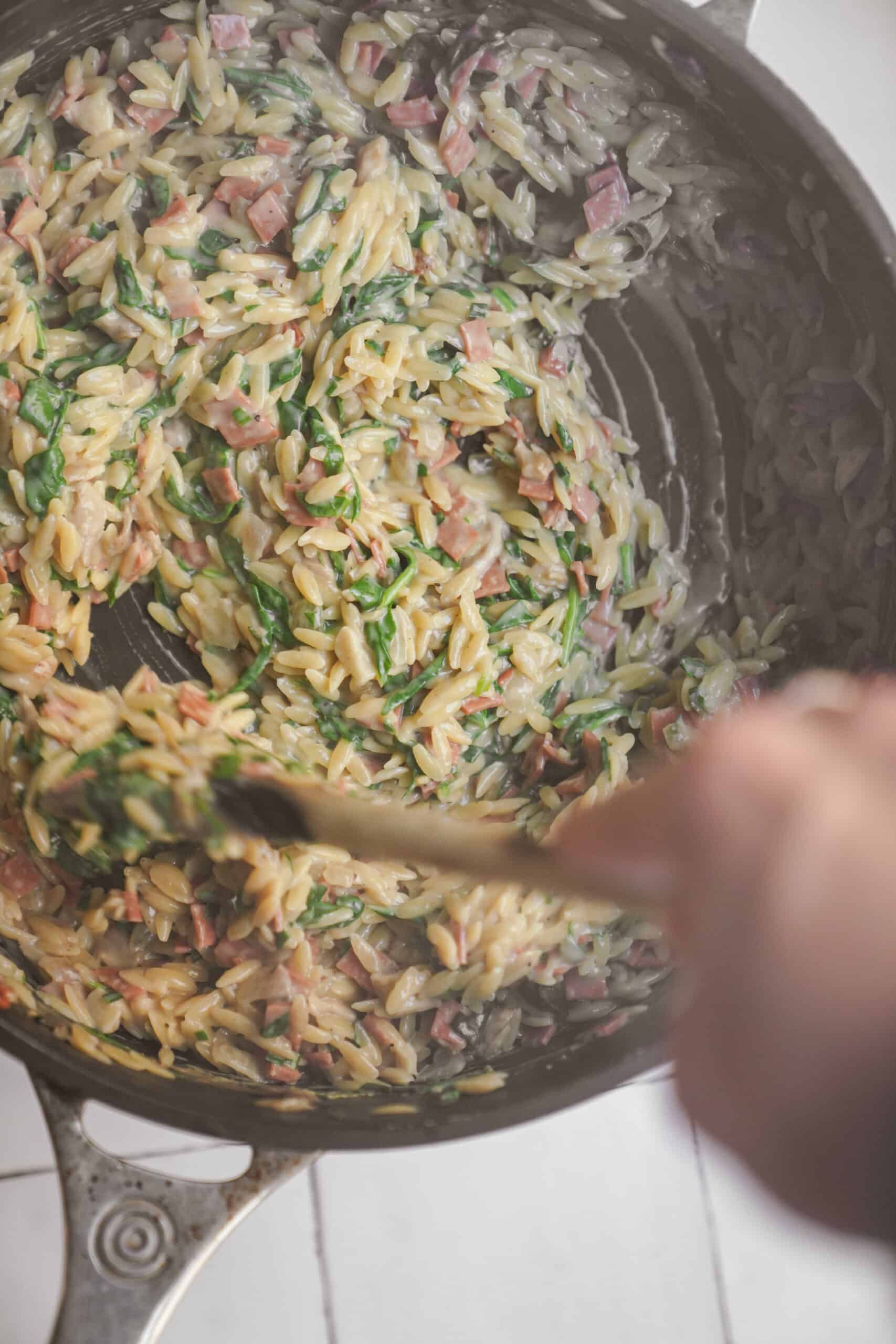 Orzo carbonara being stirred