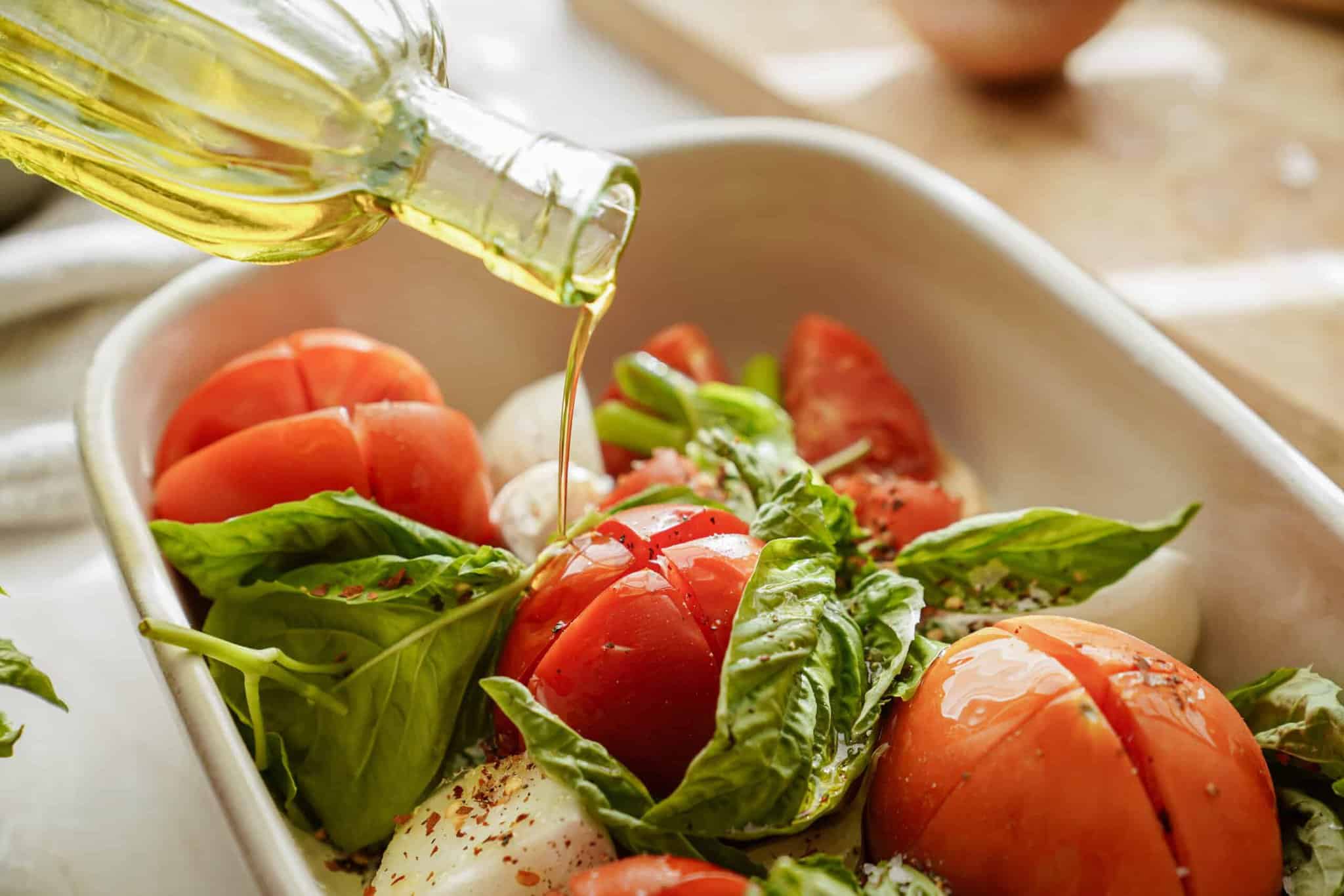 Ingredients for vegan tomato soup in a casserole dish with olive oil