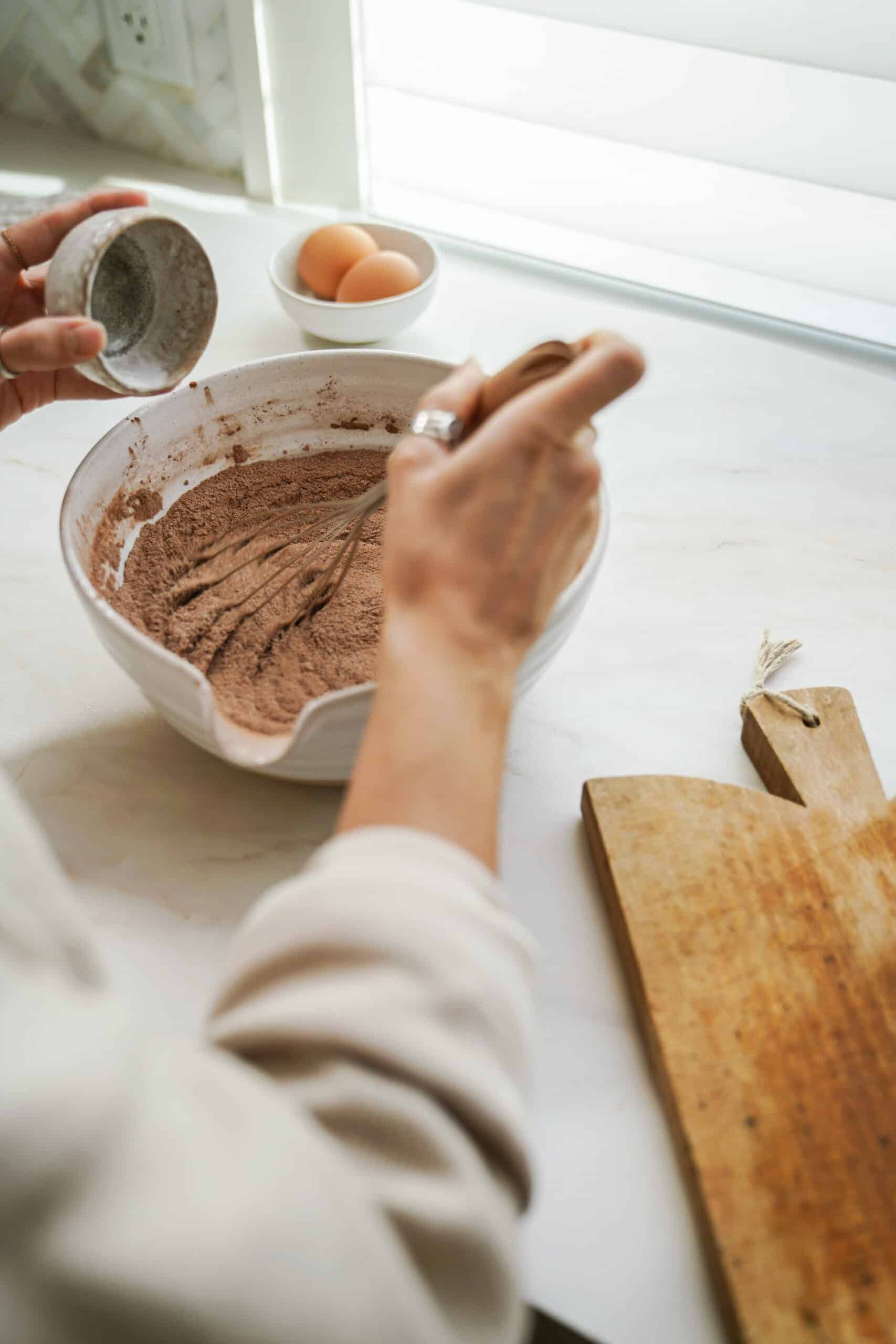 Dry ingredients being added and whisked into a bowl