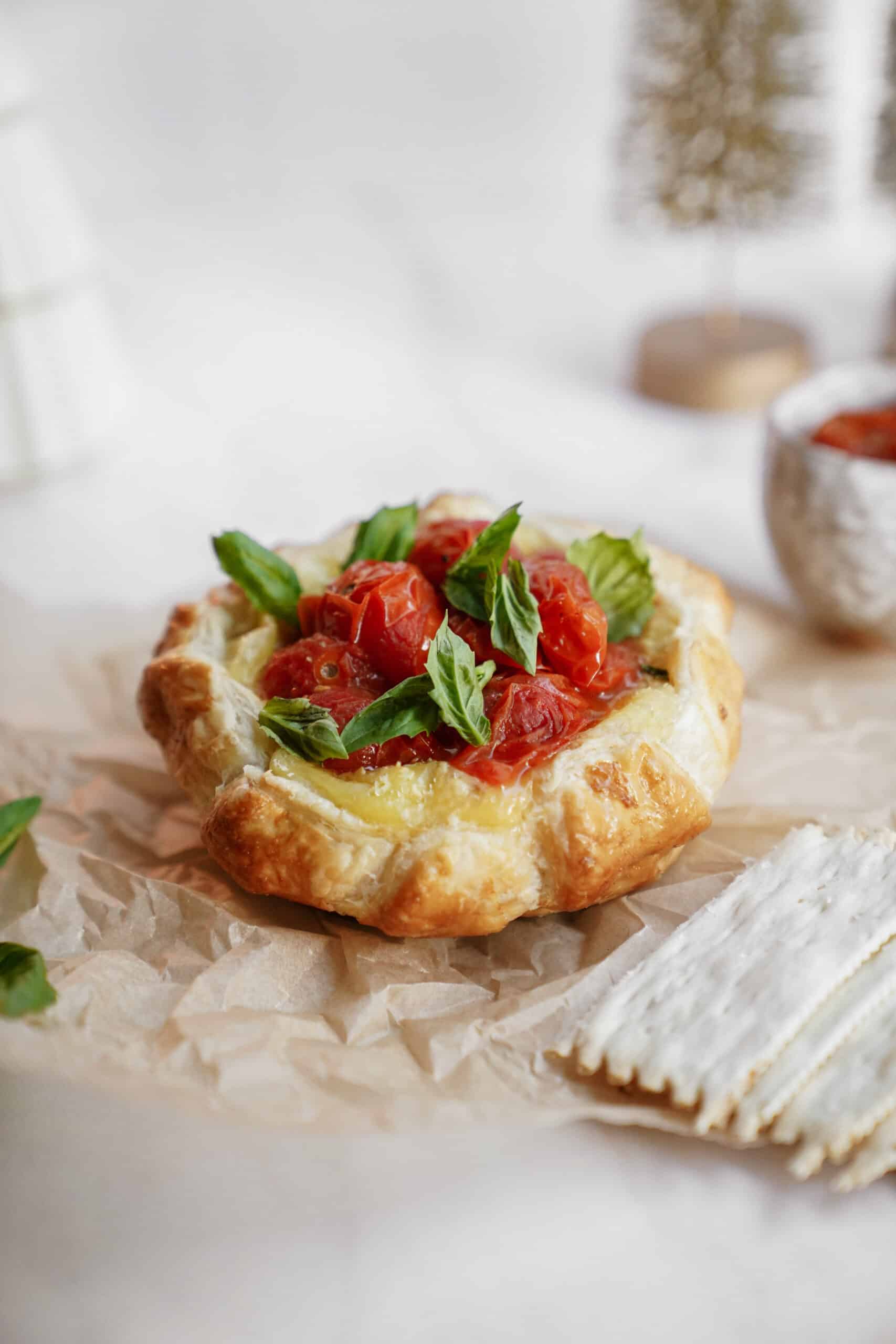 Baked brie recipe on a counter surrounded by holiday decor