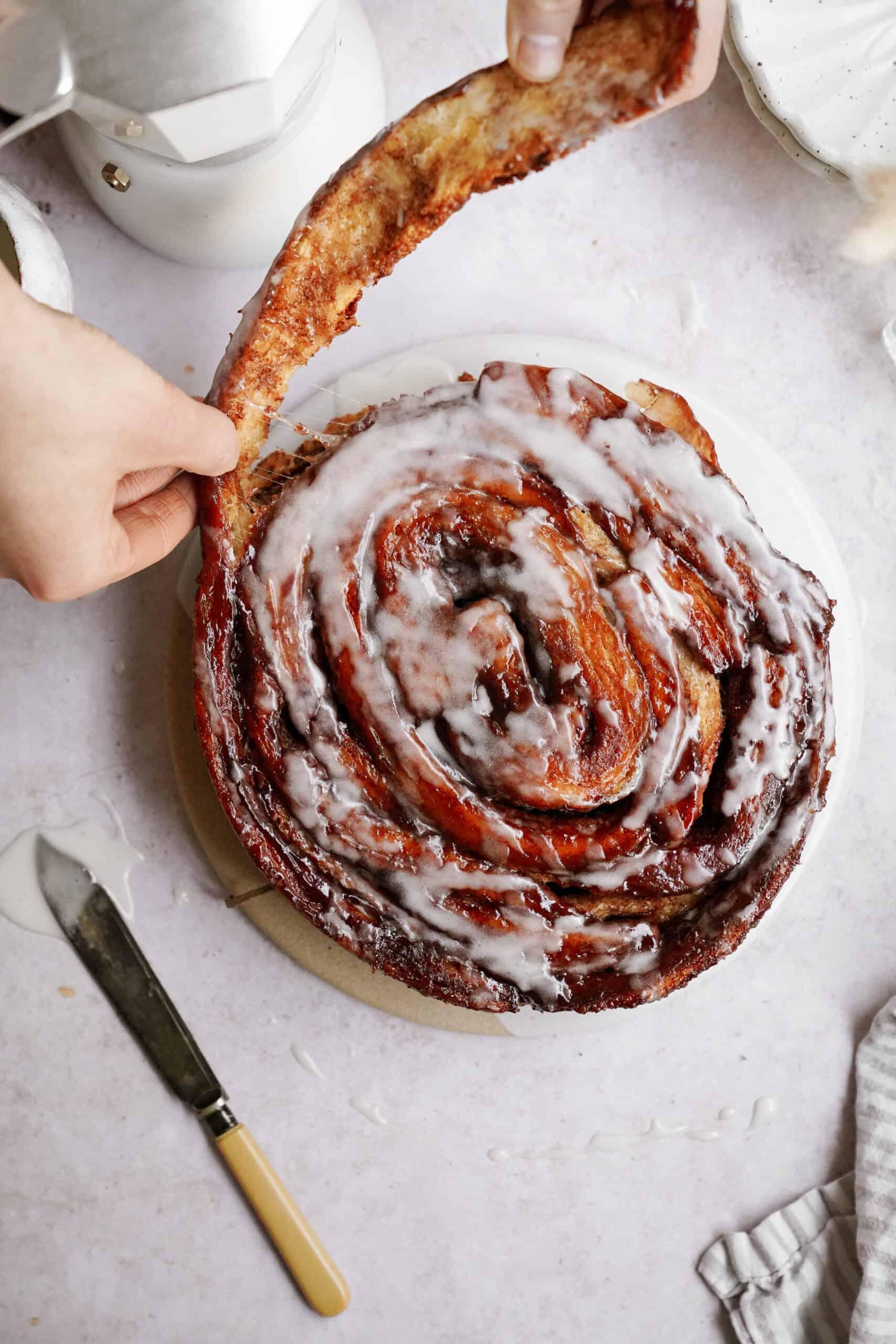 Peeling off a piece of a giant cinnamon rolls