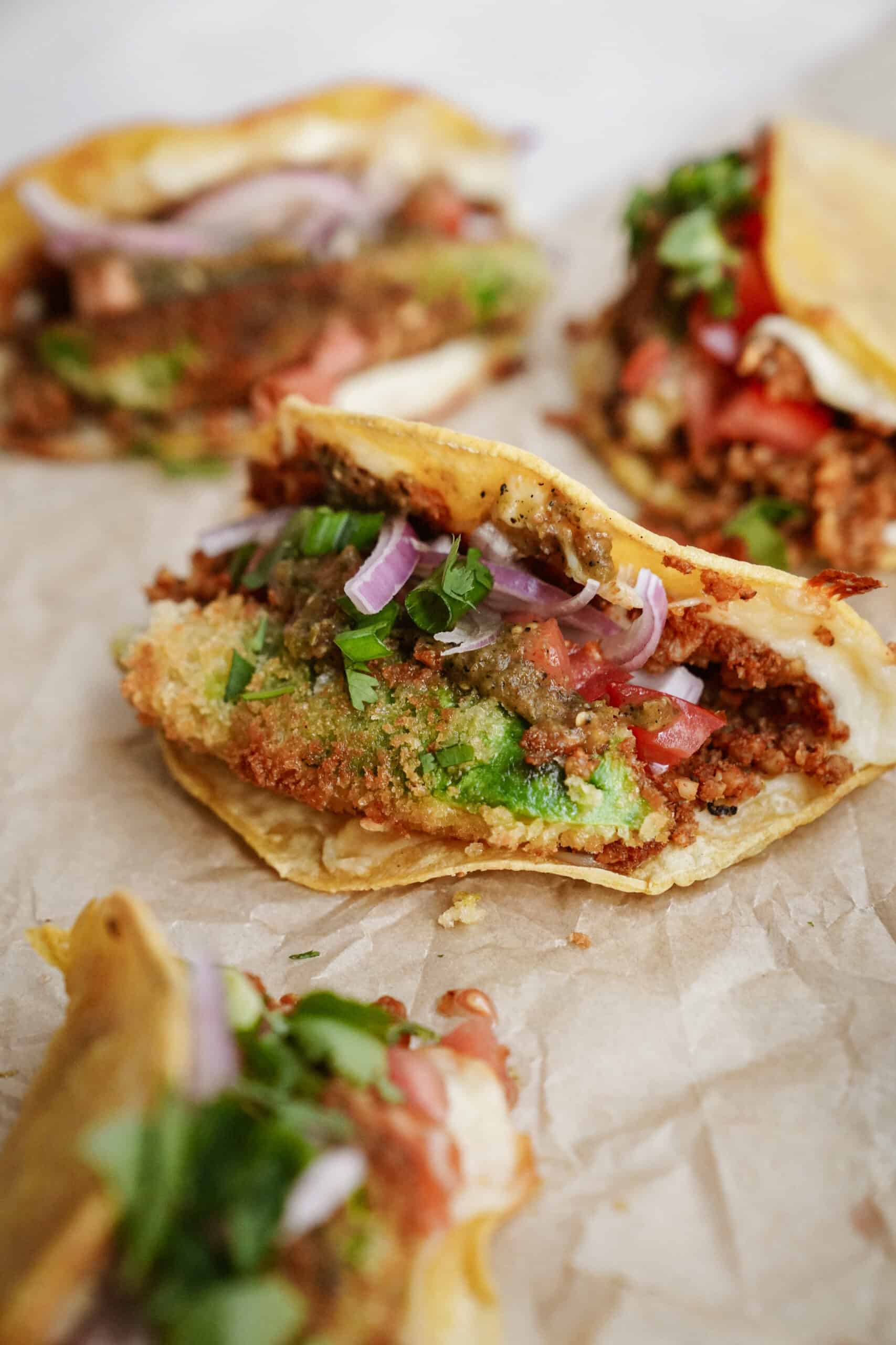 Oven baked tacos laying on parchment paper 