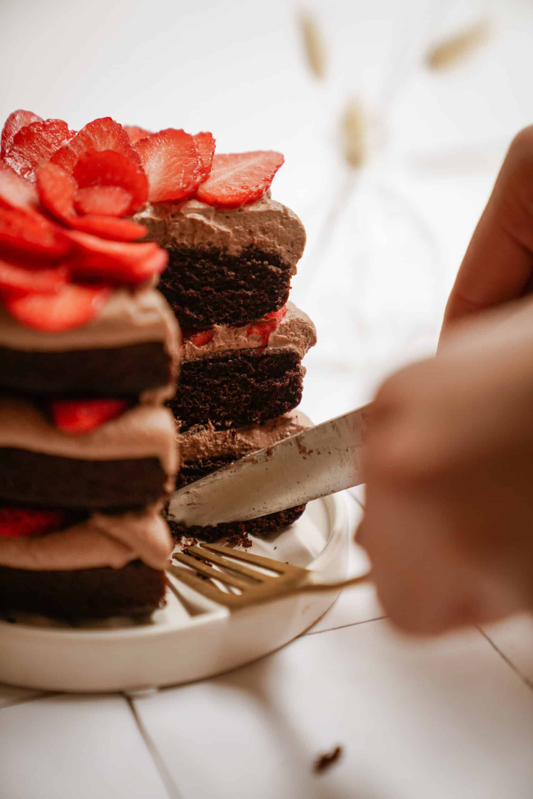 Gluten-free chocolate cake on a plate with a slice out of it