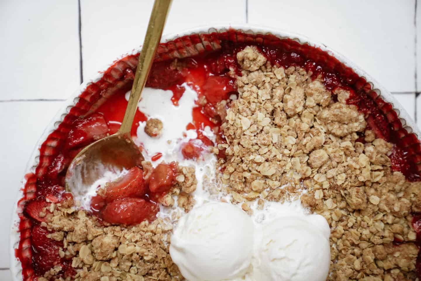 Close-up of strawberry crumble with vanilla ice cream on top